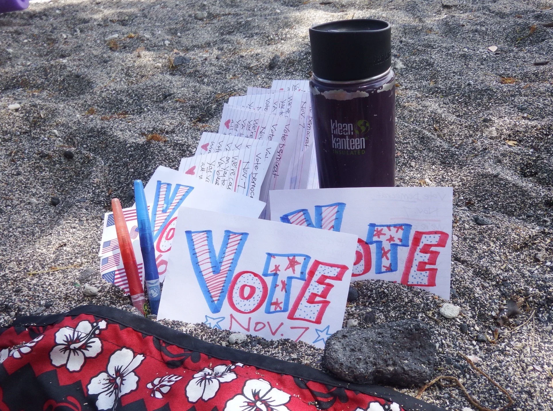 Flyers with the word ‘Vote’ in red, white, and blue colors lying on the sand