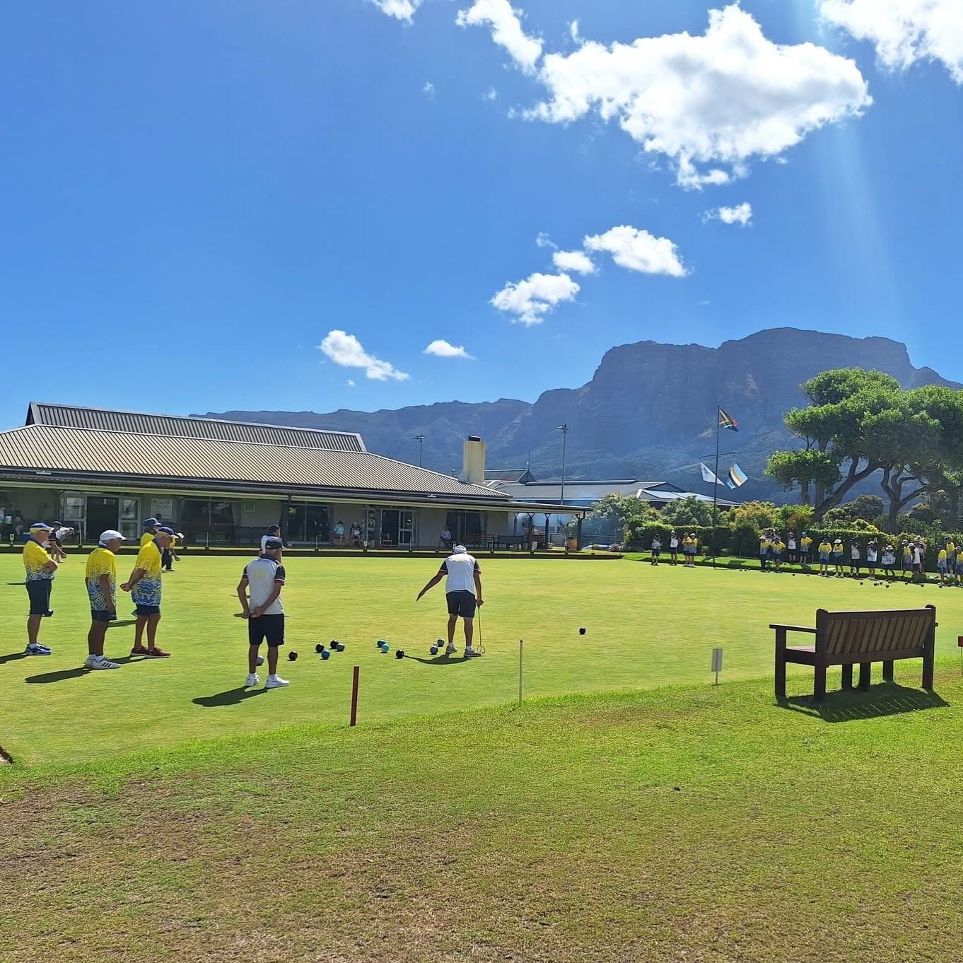 People playing lawn bowls at Western Province Cricket Club on a sunny day with Table Mountain in the background.