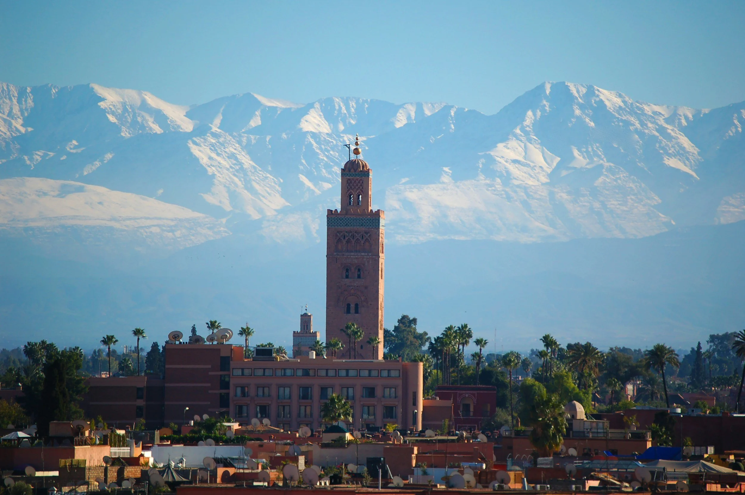 Koutoubia Moschee vor schneebedeckten Bergen.