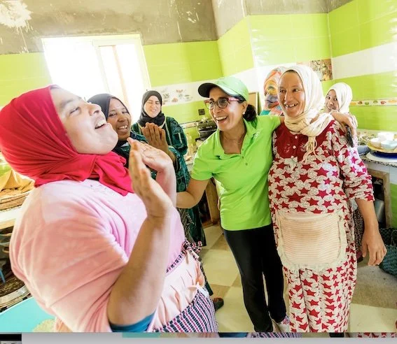 Frauen stehen in einer Küche im Berberdorf und lachen.