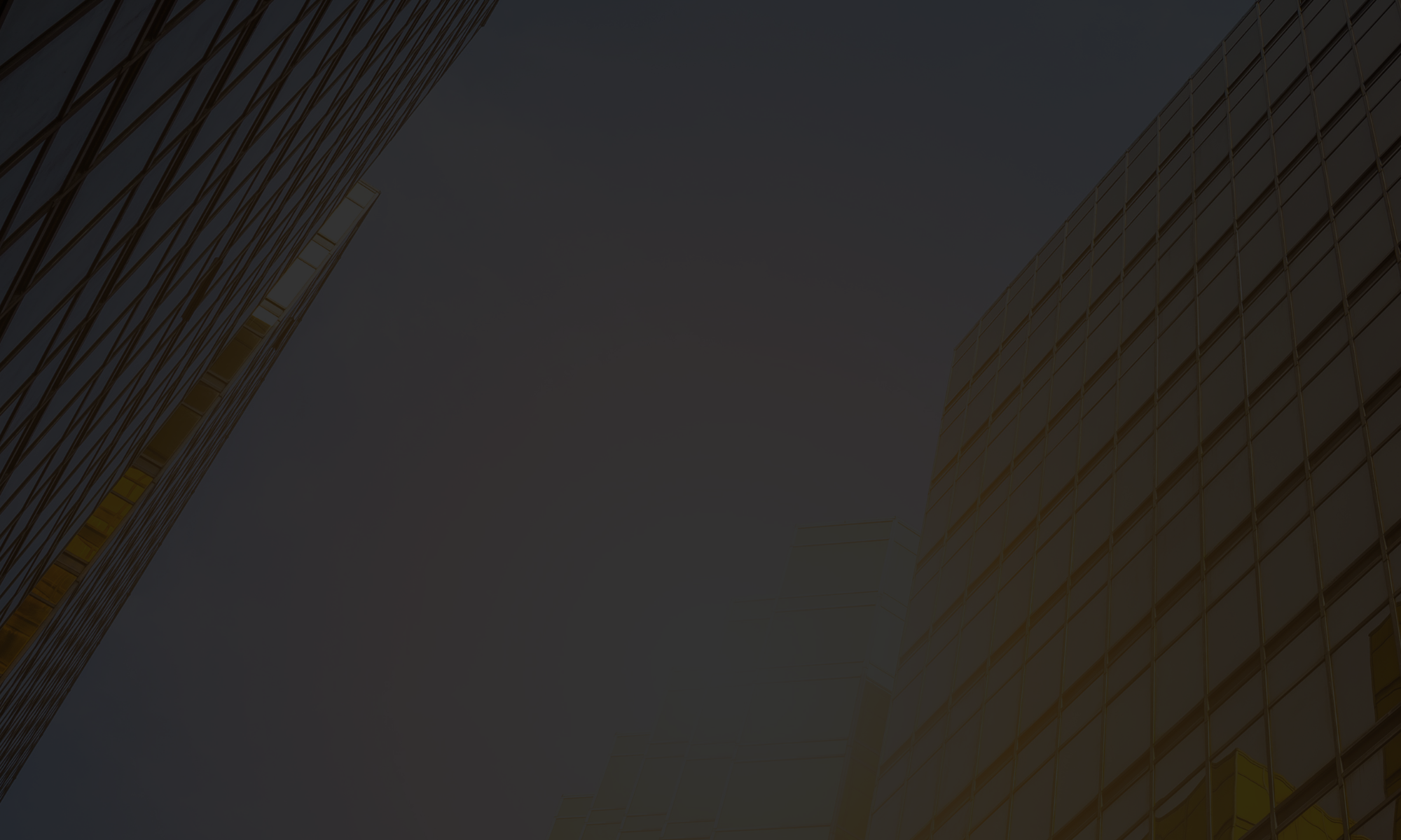 Office renovation contractor made tall office buildings with glass windows viewed from below against a dark, overcast sky.