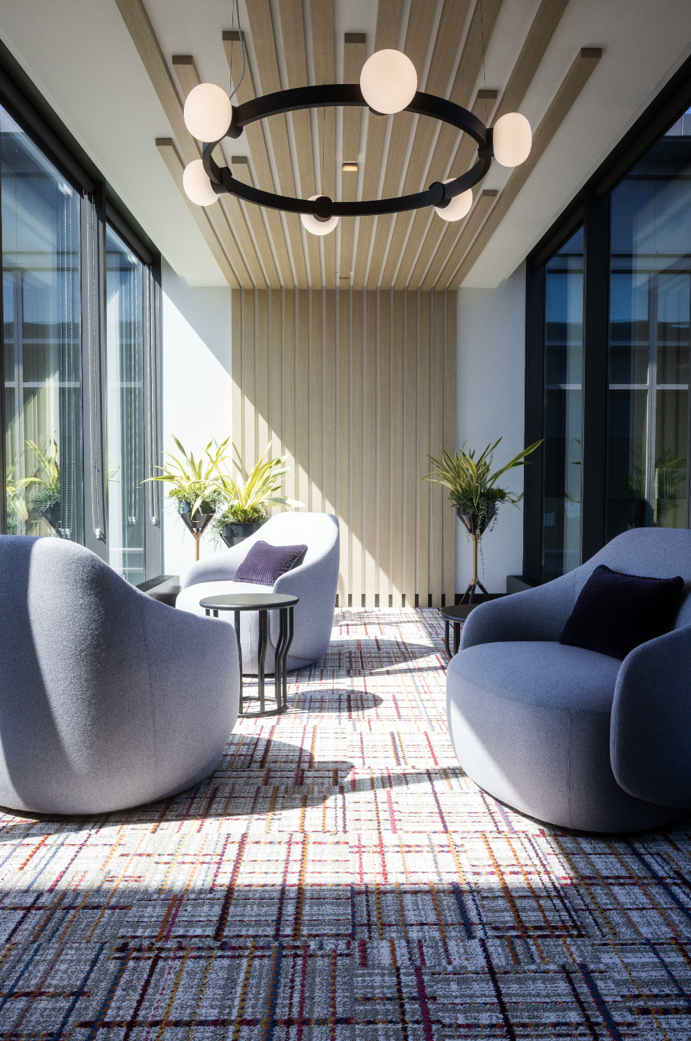 Image of INEOS office space sitting/casual area with 4 chairs, wall panelling, light fixture.