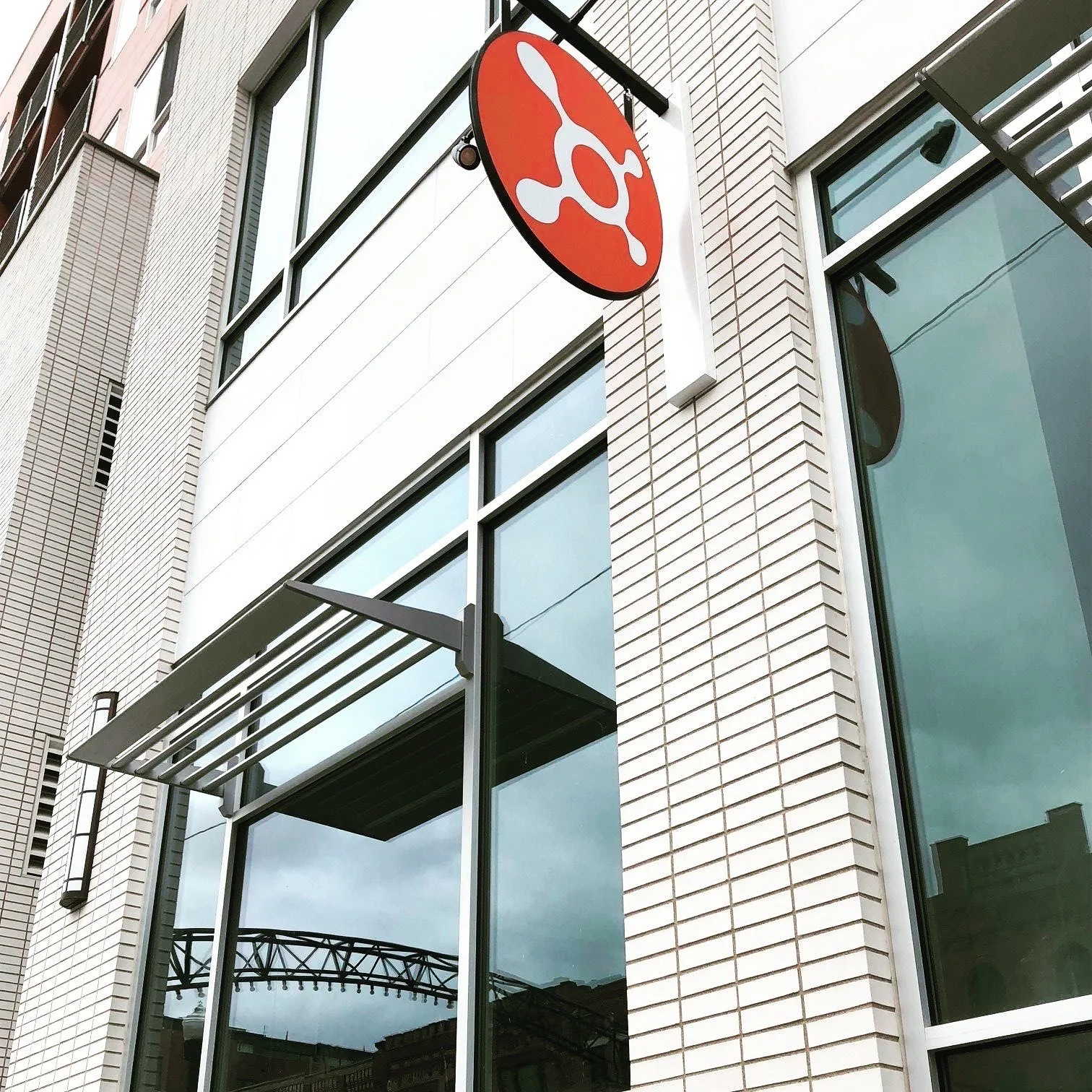 A family-owned construction company created a modern building facade with large windows and an orange Orangetheory Fitness sign above the entrance.