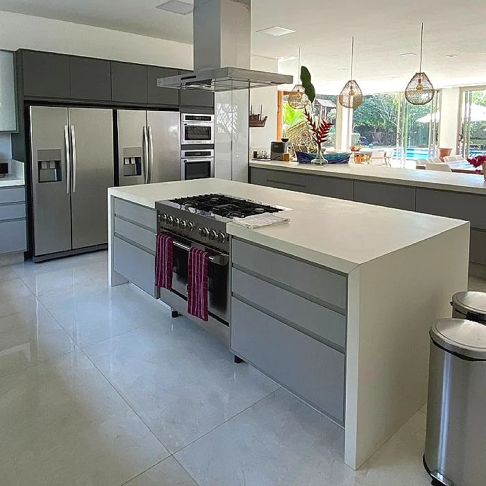 Cozinha moderna com ilhas, geladeiras de aço inox, forno embutido, cooktop na ilha central, janelas grandes e iluminação natural