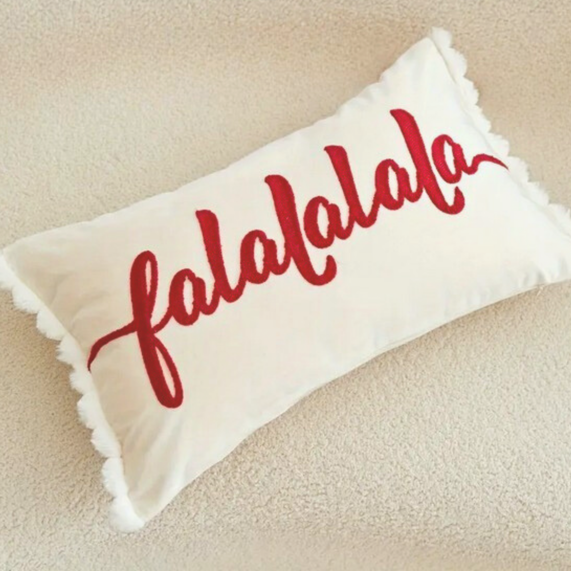 Cream Falalalala Christmas cushion with red lettering and white pom pom trim