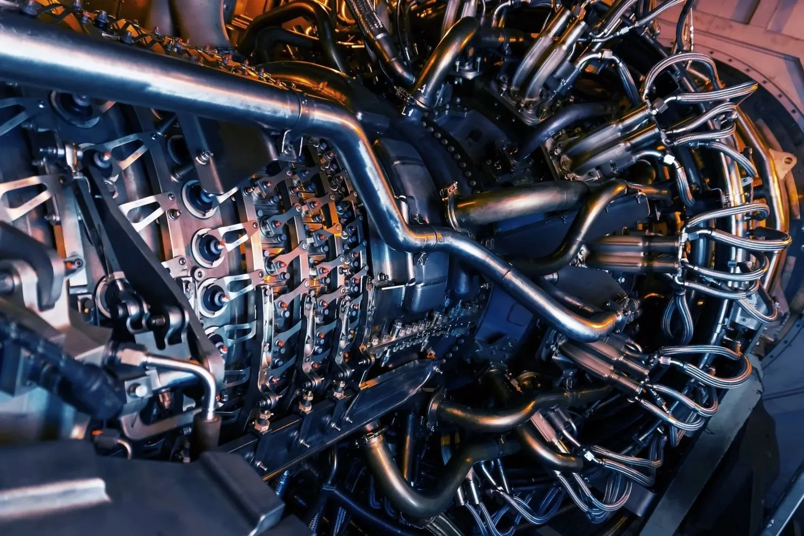 Close-up view of a complex jet engine engine's internal components including pipes, tubes, and mechanical parts.