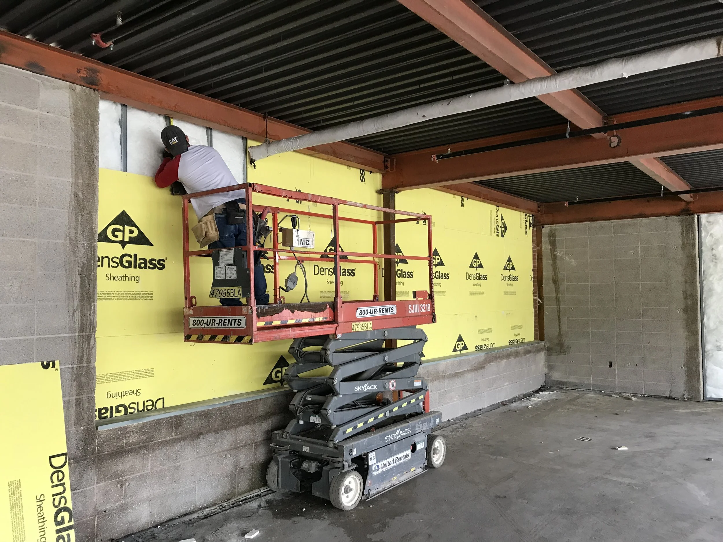 worker on lift measuring for drywall.jpg