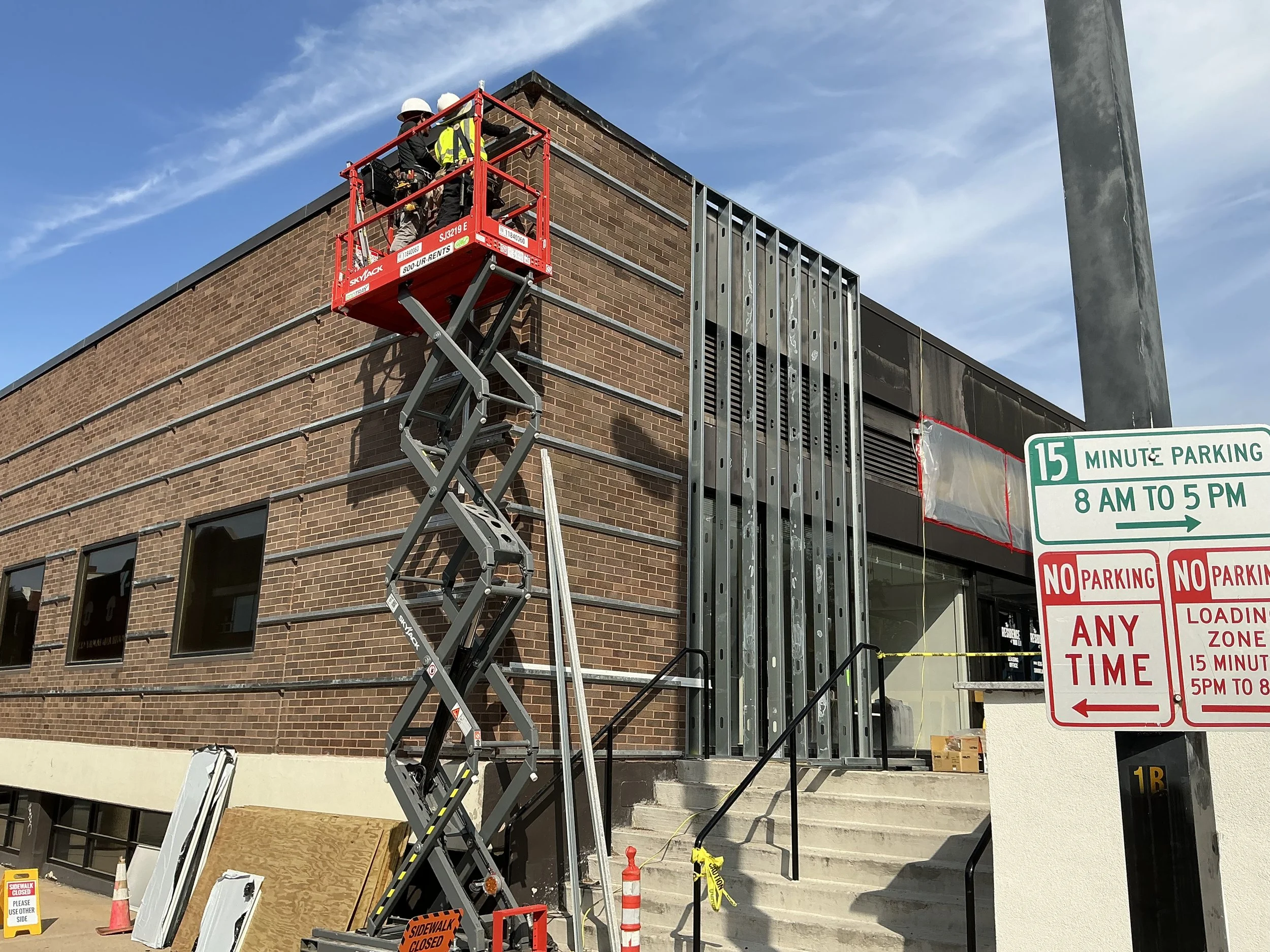 workers on lift exterior metal framing.jpg