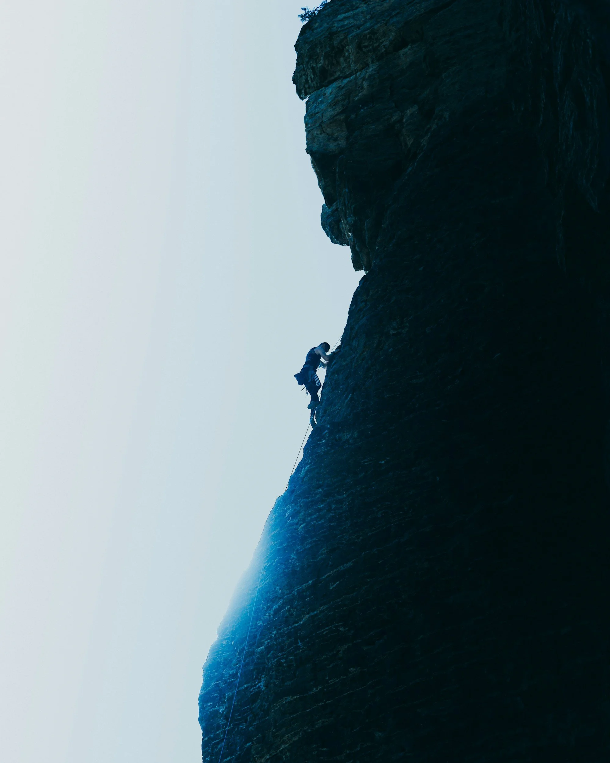 person climbing a mountain symbolizing trying to reach unrealistic standards or expectations