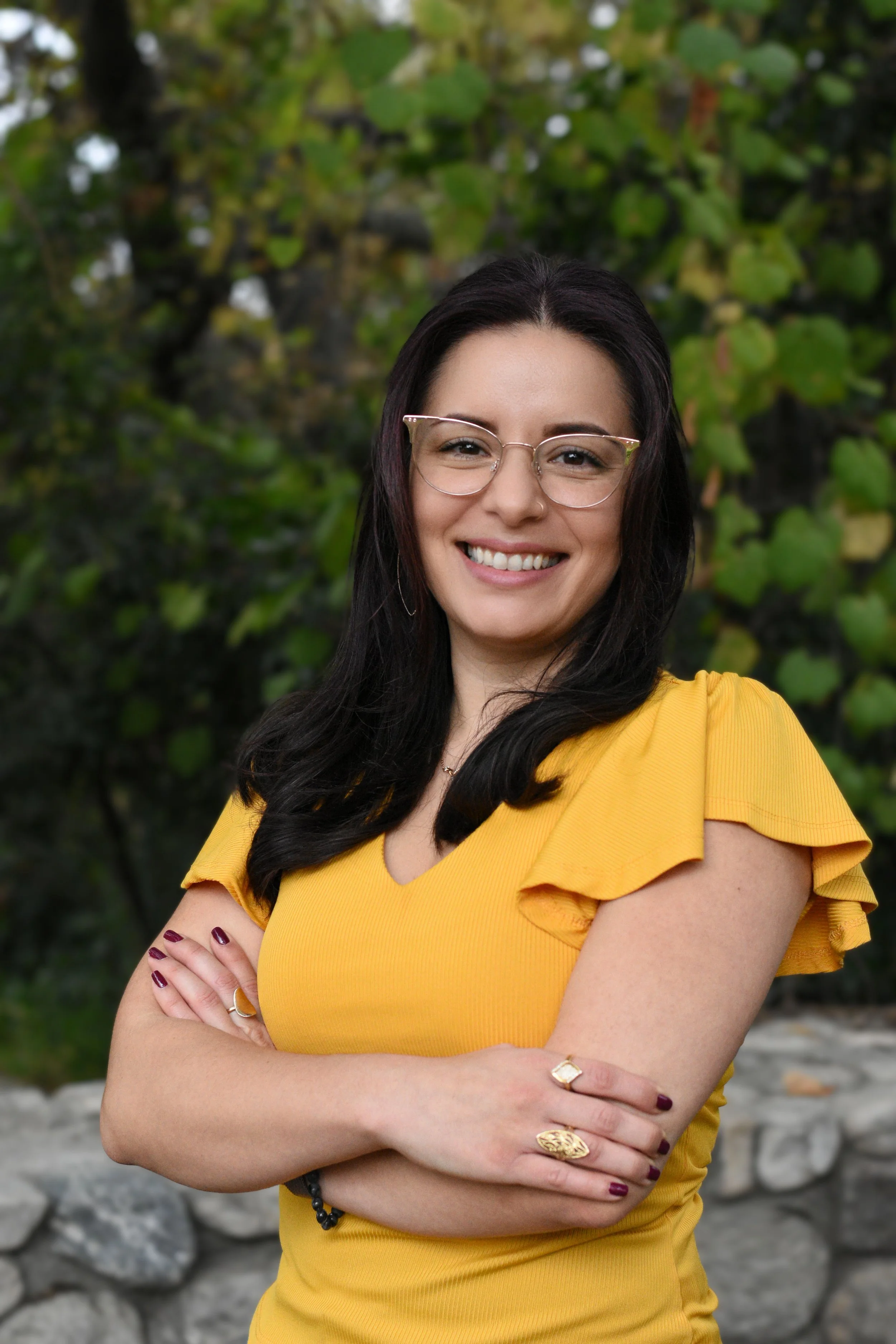 therapist Lili outdoors smiling with greenery and natural light