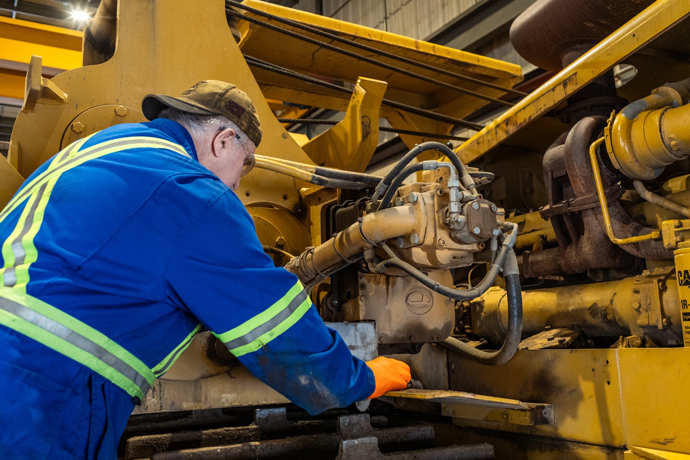 technician performing heavy duty equipment repair on industrial machinery