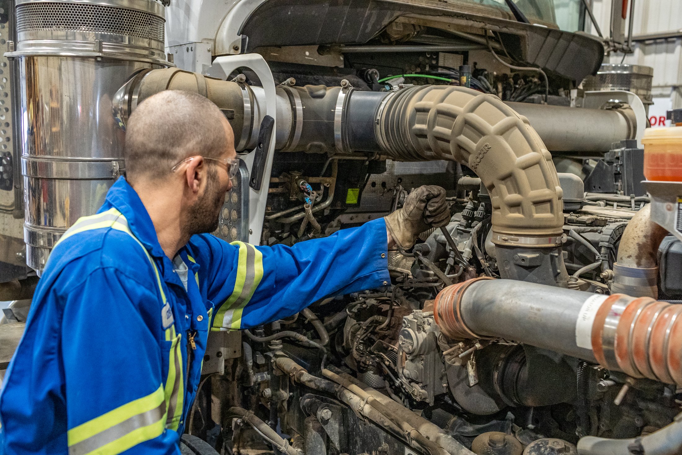 technician performing preventive maintenance on heavy duty engine components