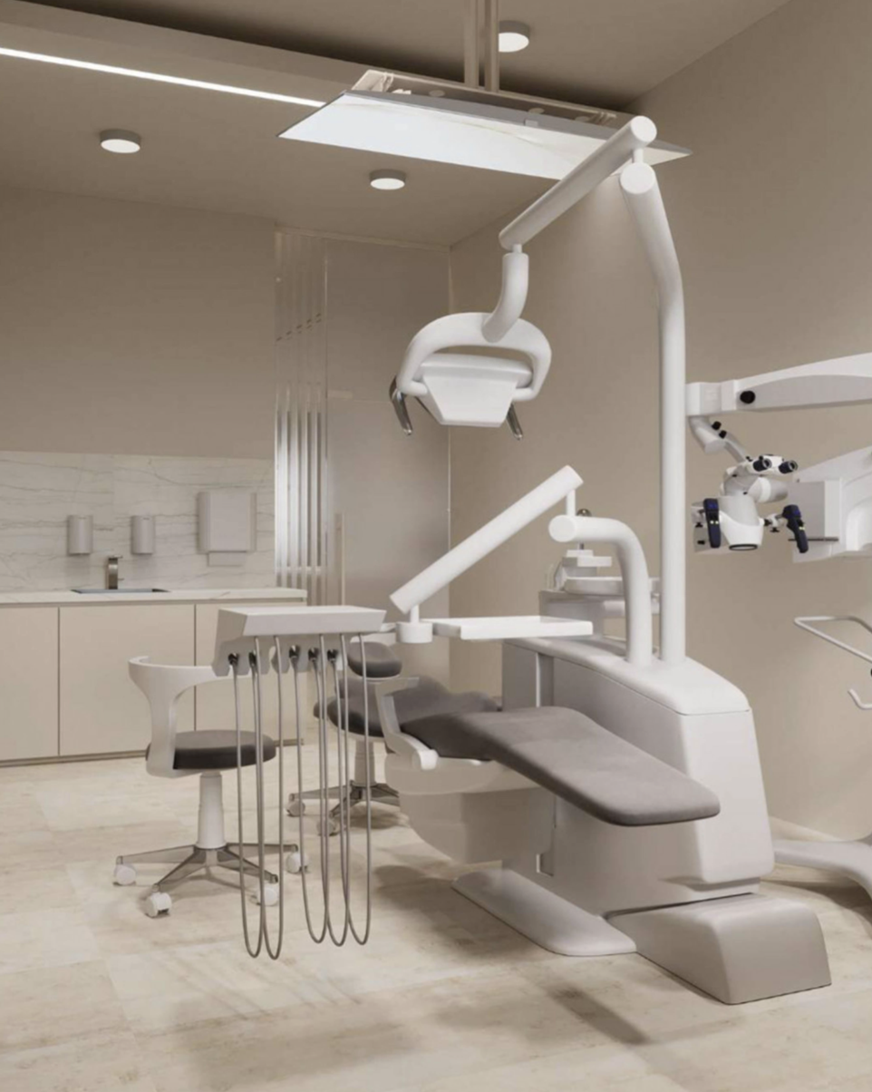 Dental examination chair with attached overhead light, dental tools hanging from a tool holder, and a microscope, in a clean, modern dental office.