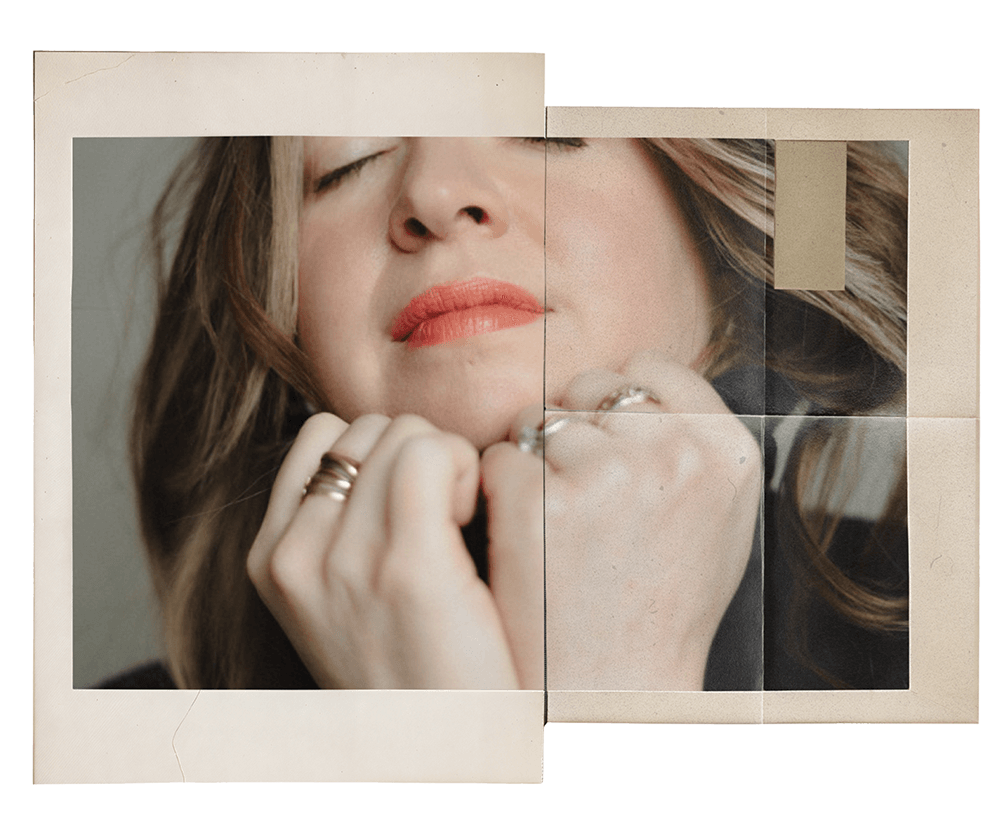 Close-up of a woman with closed eyes, light brown hair, red lipstick, and rings on her fingers, resting her chin on her hand.
