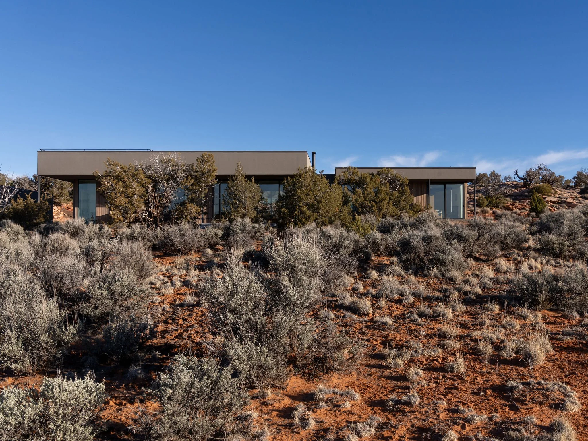 Low modern home settled into the sagebrush and slickrock desert, Flat Iron Mesa, Moab, Utah.
