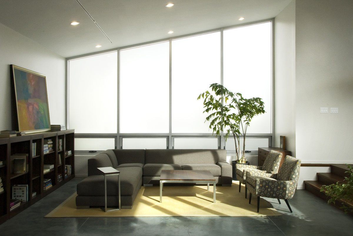 Modern living room with a sectional, art, and a wall of frosted-glass windows, McClelland, Salt Lake City, Utah.