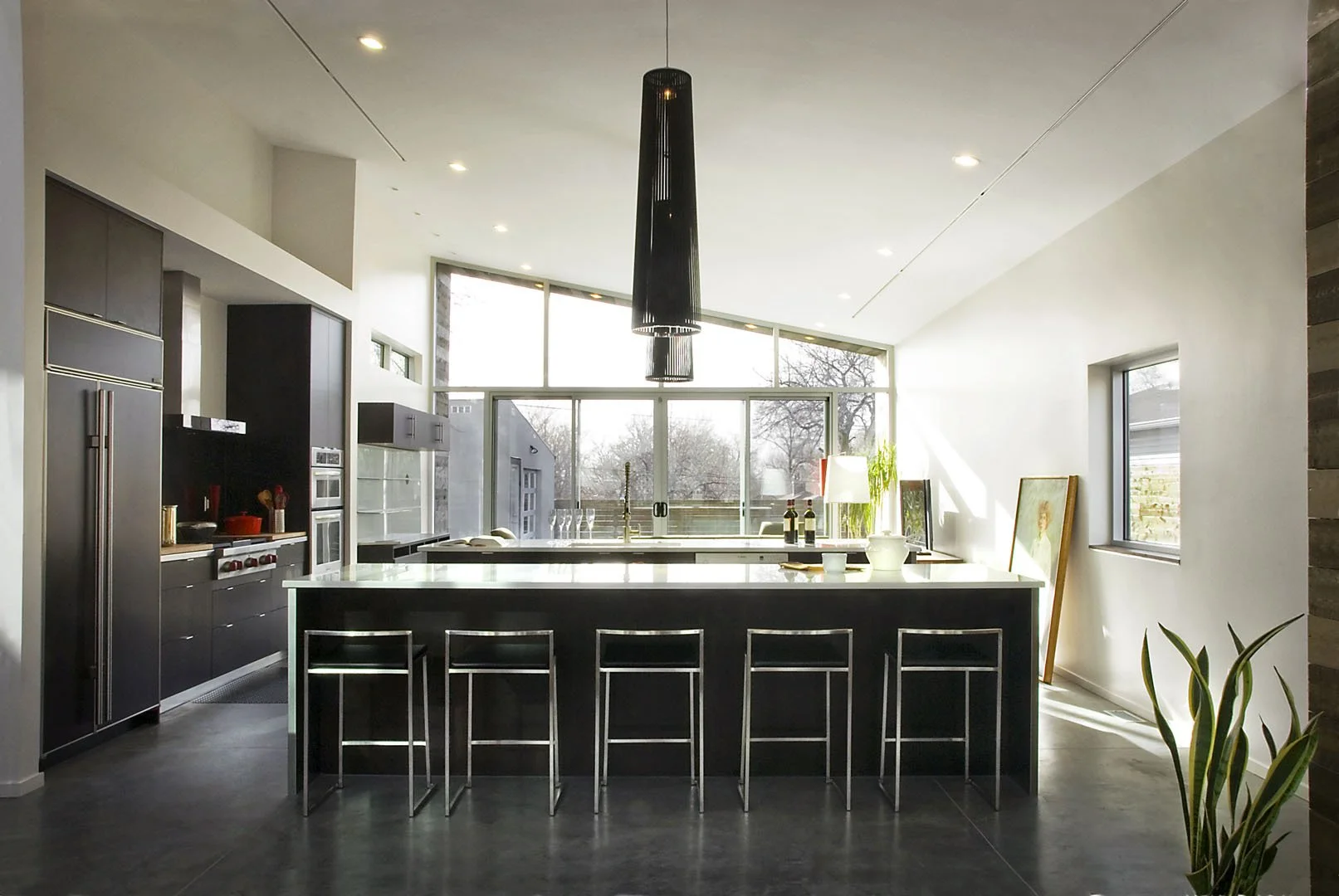Modern kitchen with dark cabinetry, a long island with bar seating, and clerestory windows, McClelland, Salt Lake City, Utah.