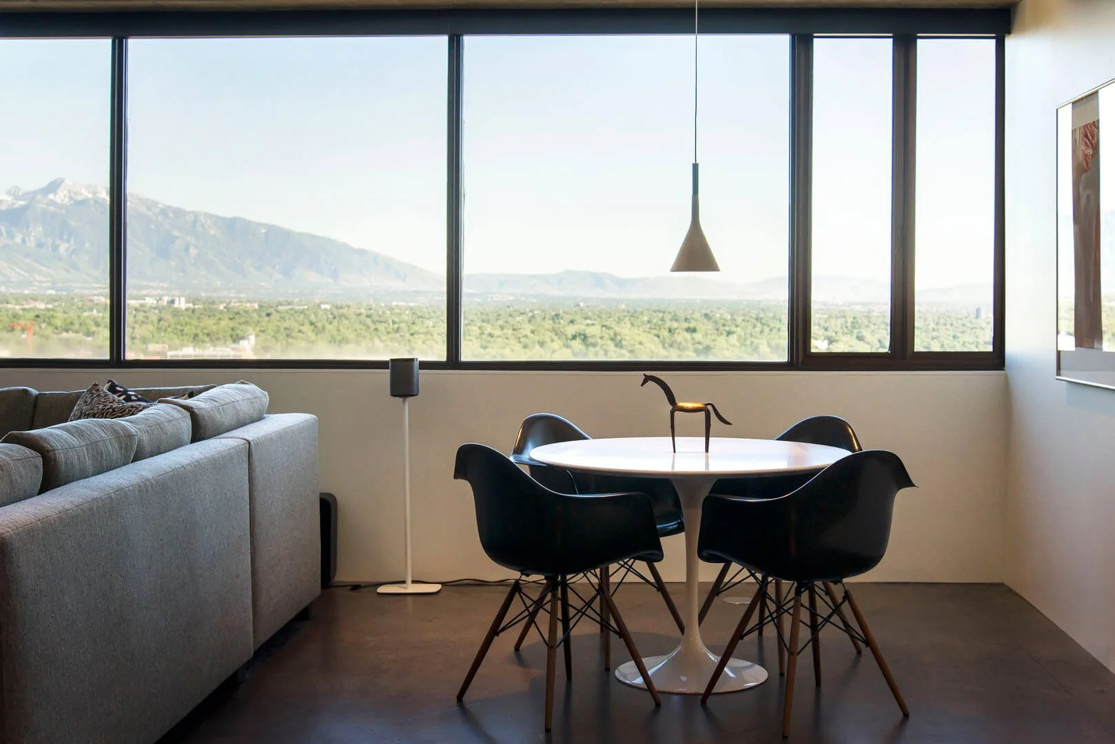 Dining nook with a round table framed by a wall of windows overlooking the mountains and valley, Governors Plaza South, Salt Lake City, Utah.