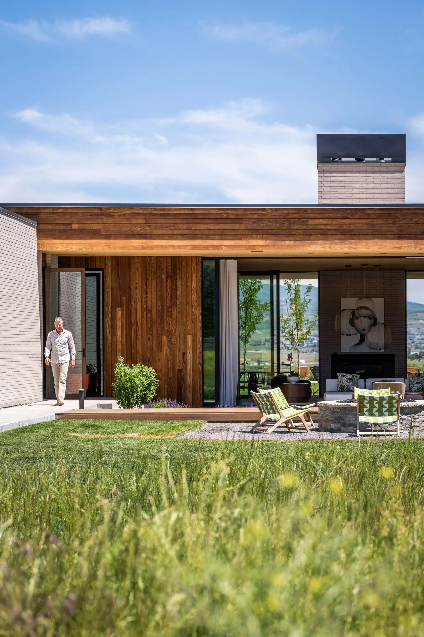 Cedar-clad entry opening to an outdoor living area with fire pit, Spring Creek, Park City, Utah.