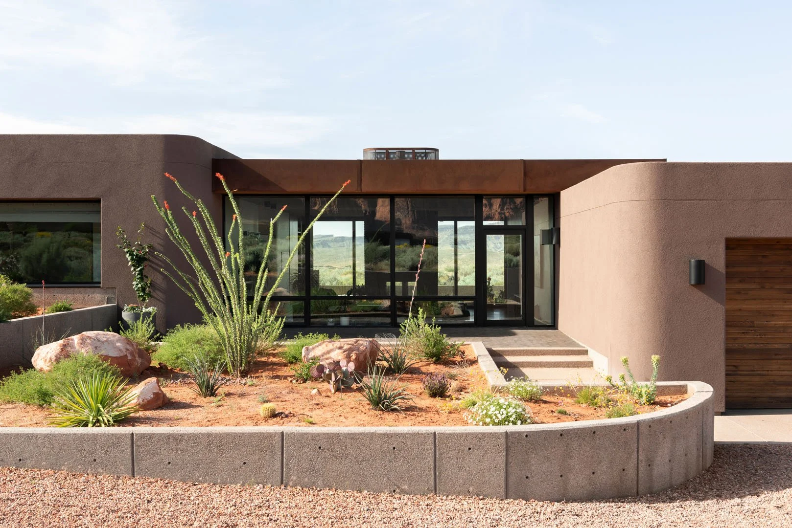 Single-level modern desert home behind a native garden of ocotillo and boulders, Taviawk, Ivins, Utah.