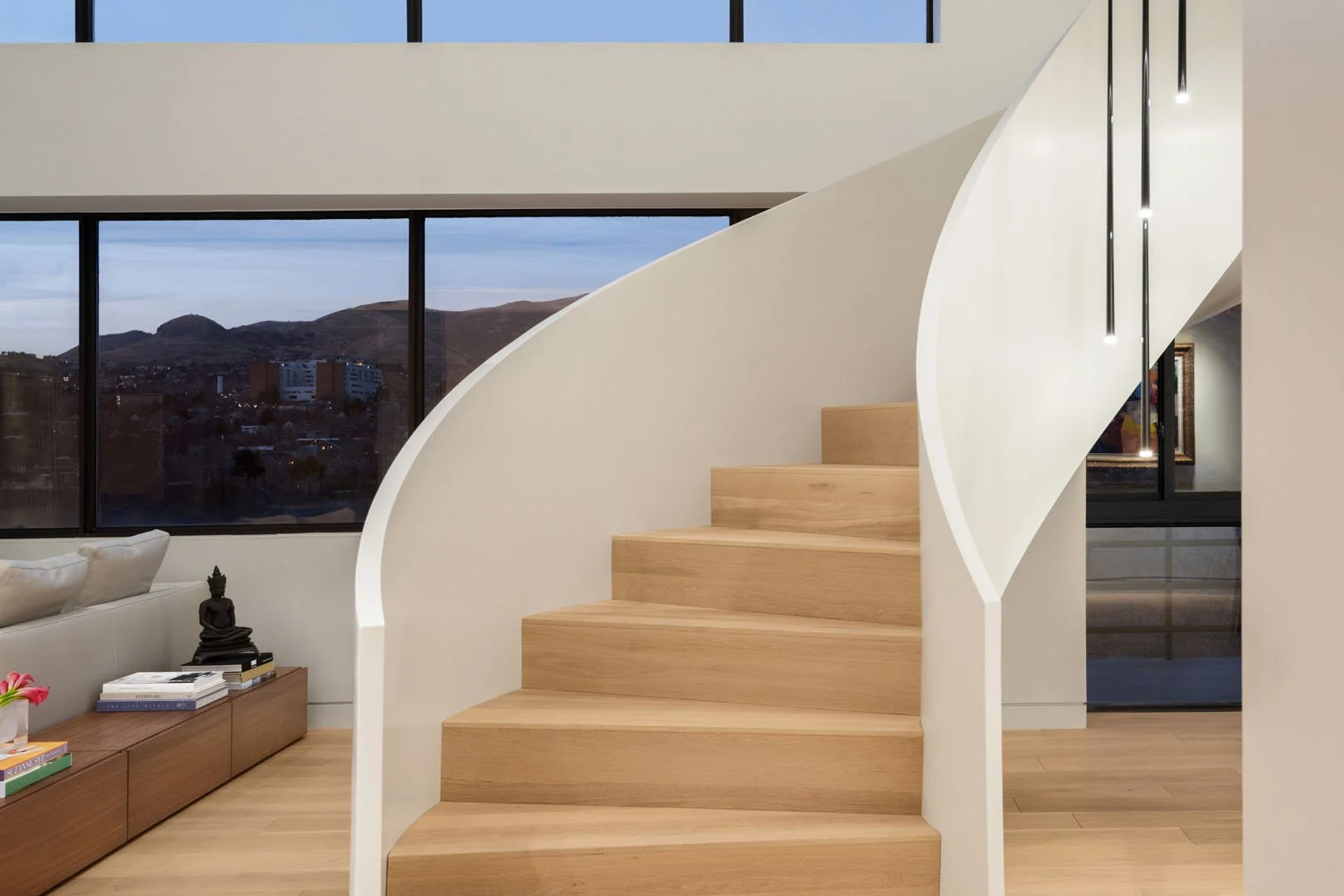 Contemporary staircase with glass railings and views across the open living space, Governors Plaza North, Salt Lake City, Utah.