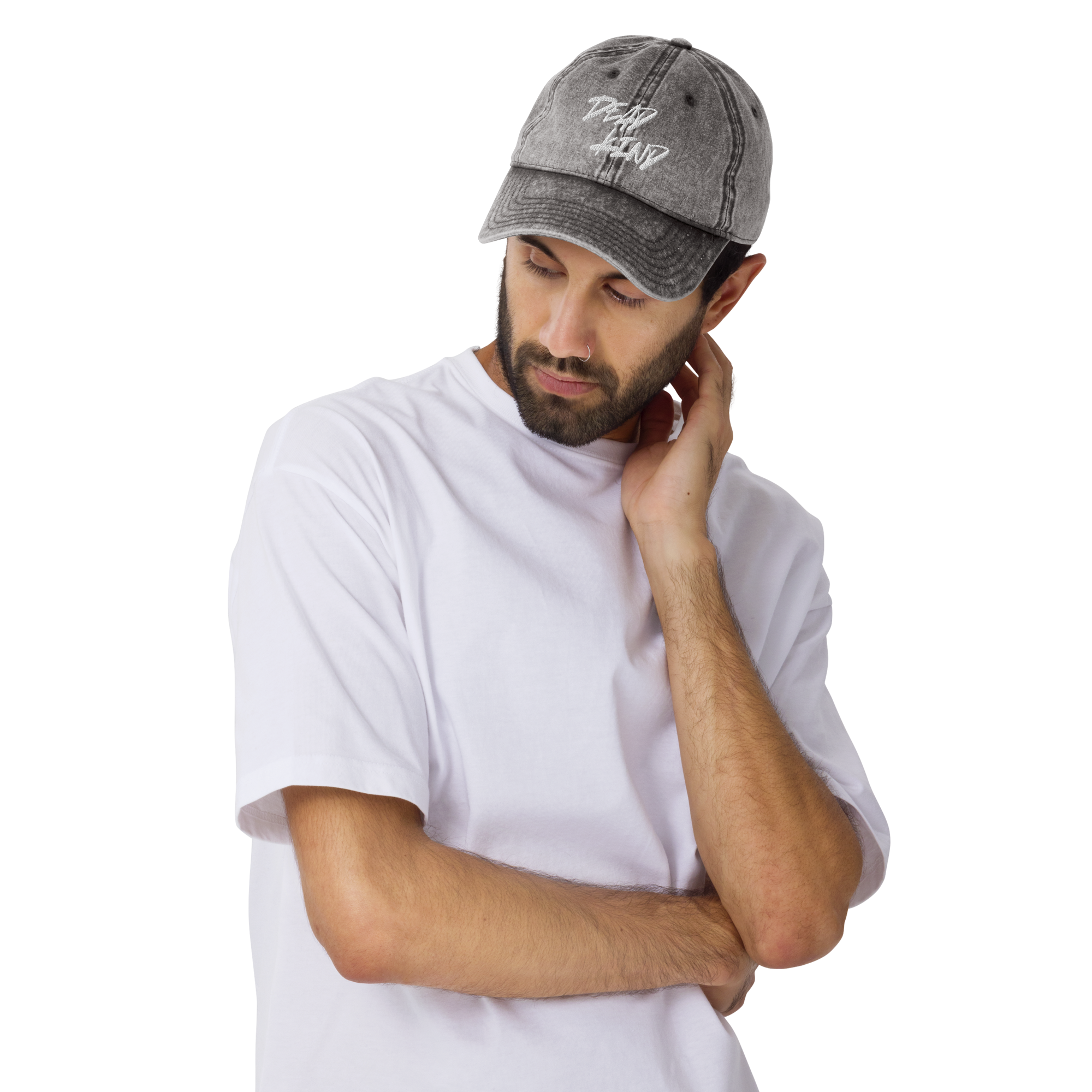 A young man with a beard touching his neck, wearing a gray baseball cap and a white t-shirt.