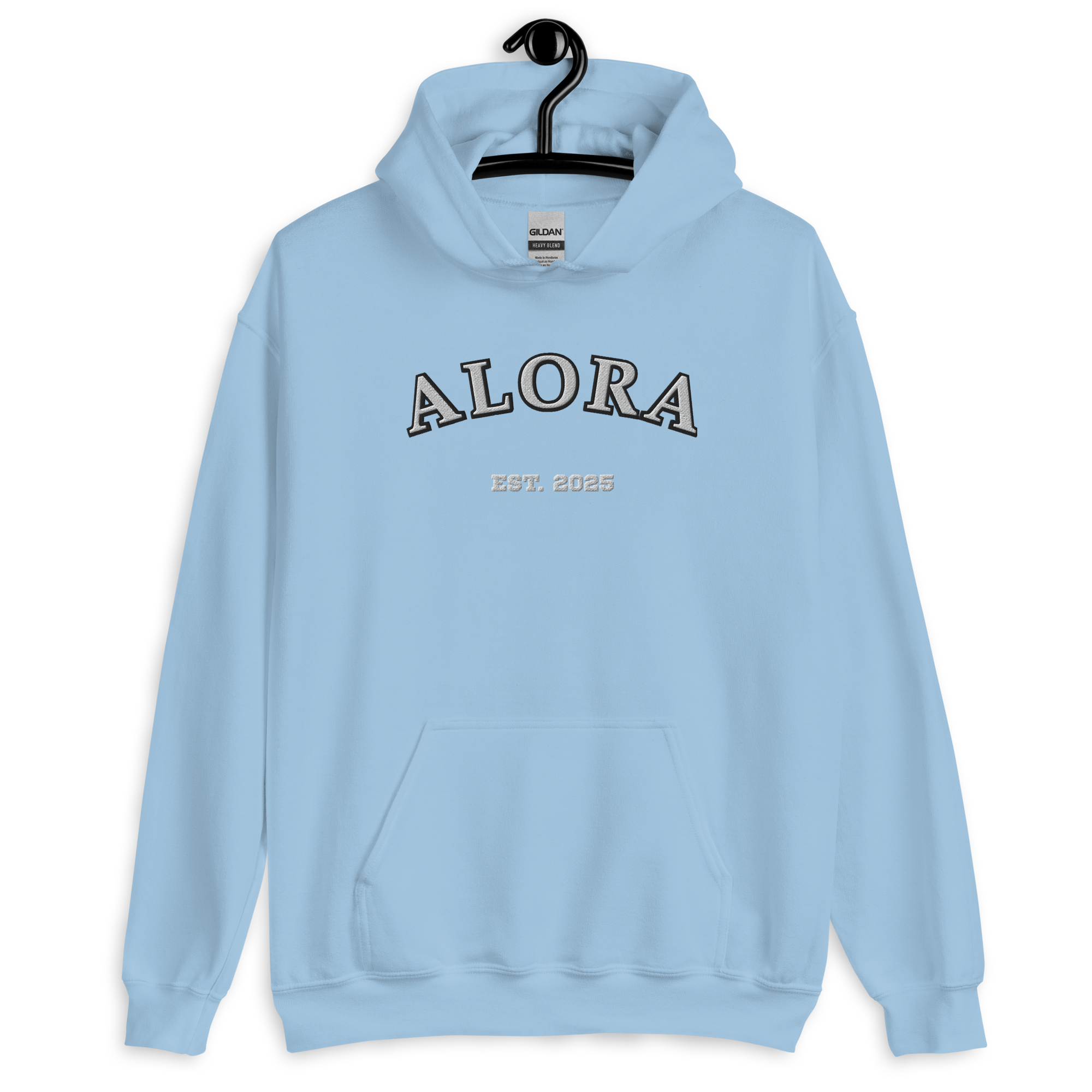 Light blue hoodie with 'ALORA' and 'EST. 2025' text on the front, hanging on a black hanger against a black background.