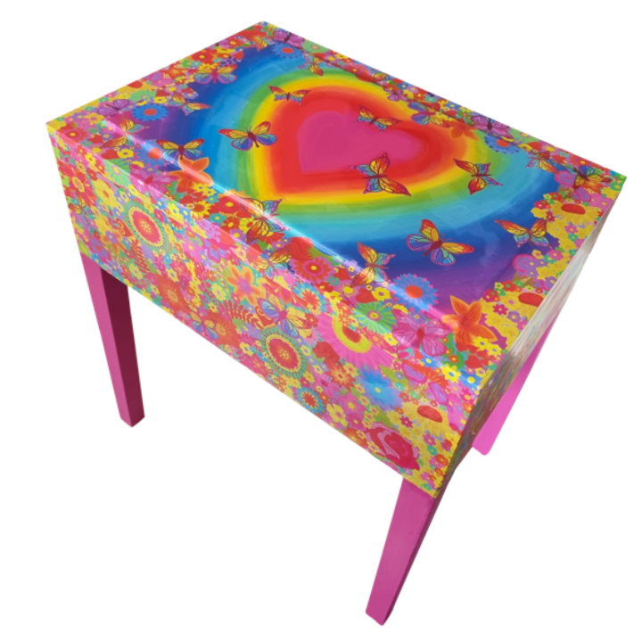 A Colourful table with a psychedelic rainbow heart and butterfly design on the top, and vibrant floral patterns on the sides, supported by pink legs.