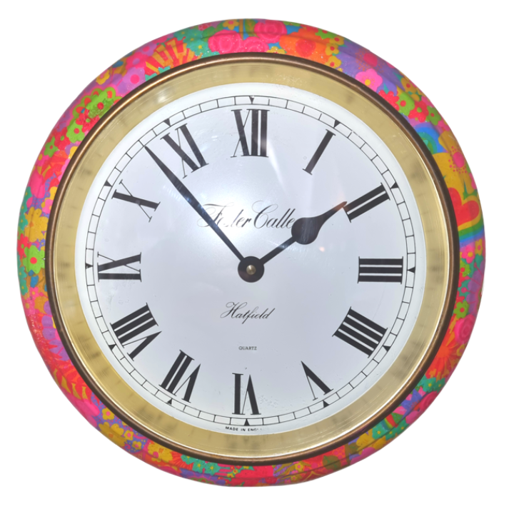 Round wall clock with a Colourful floral patterned frame, black Roman numerals, and black hour and minute hands, showing the time as 2:12.