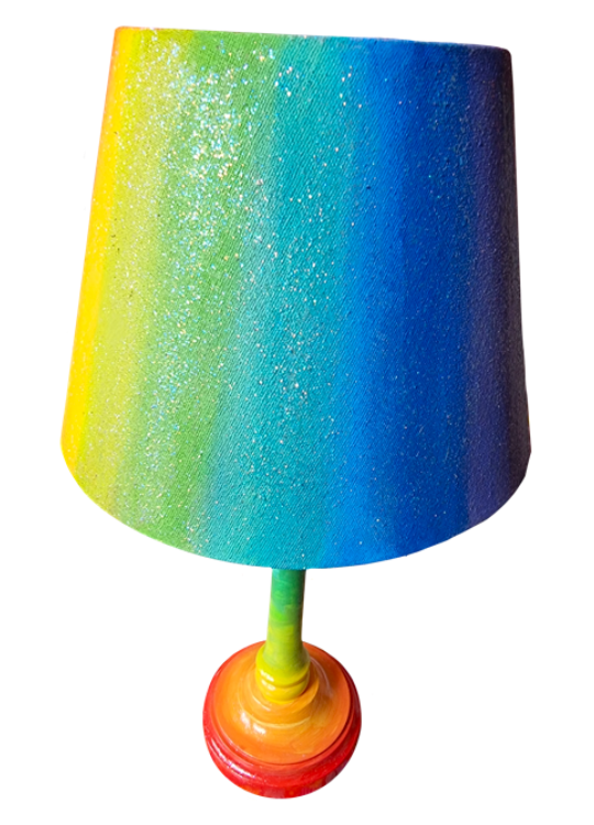 Colourful rainbow lamp with a multi-colored shade and a rainbow base.