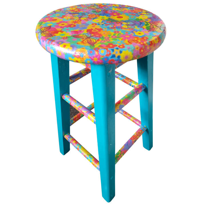 Colourful wooden stool with a round top covered in a bright, multicolored floral and butterfly pattern, with blue legs and supporting rungs.
