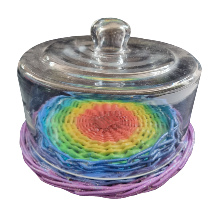 Colorful rainbow-colored woven rainbow inside a glass container with a lid.