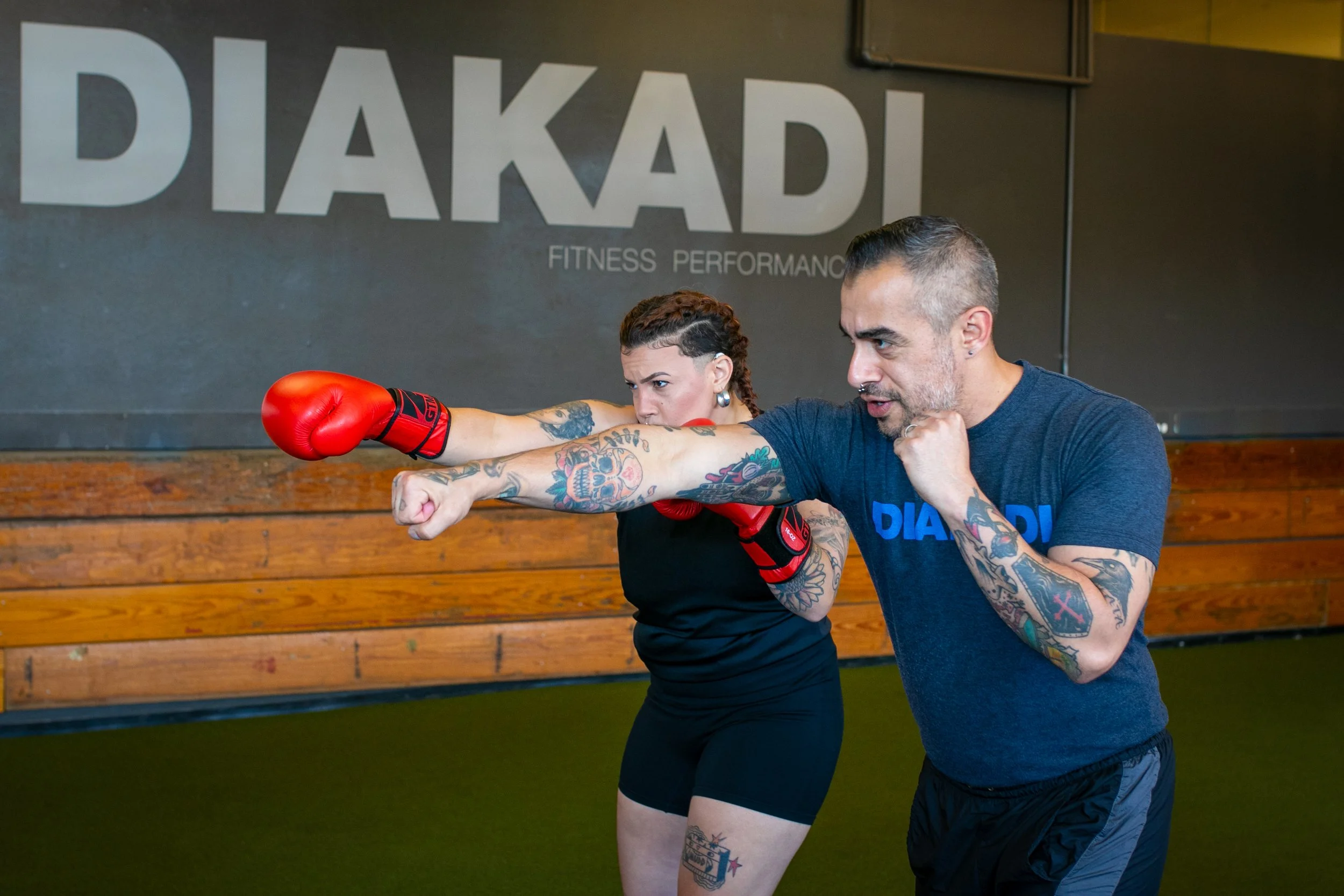 Male personal trainer using boxing techniques with female client to strengthen core.