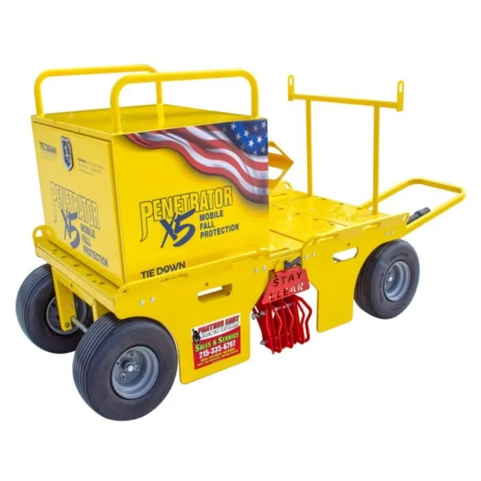 A yellow movable cart with oversized wheels and a large box marked 'Penetrator X5' for fall protection gear, featuring safety straps and a sign that says 'Stay Clear'.