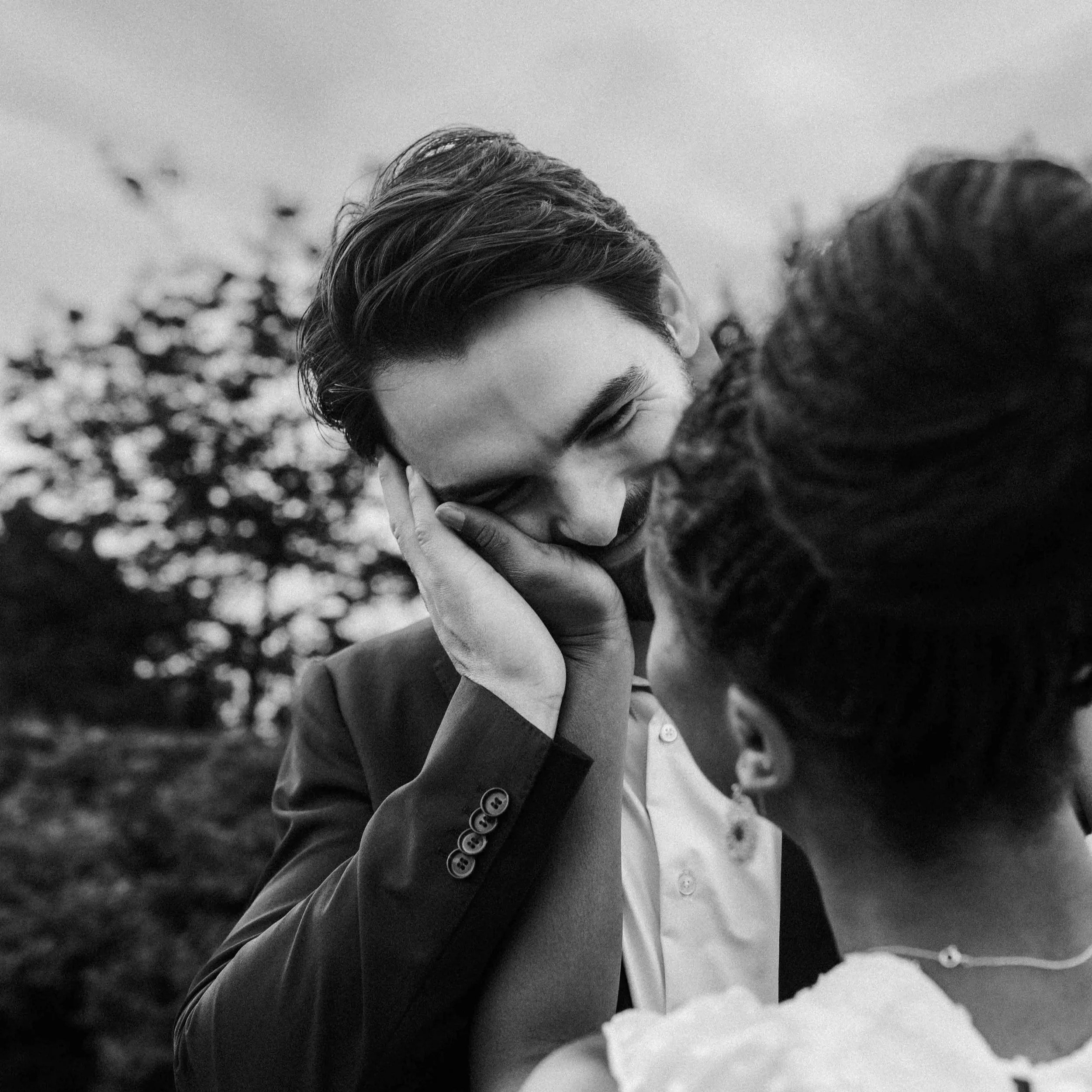 A man leans into his wife's hand, his face full of love