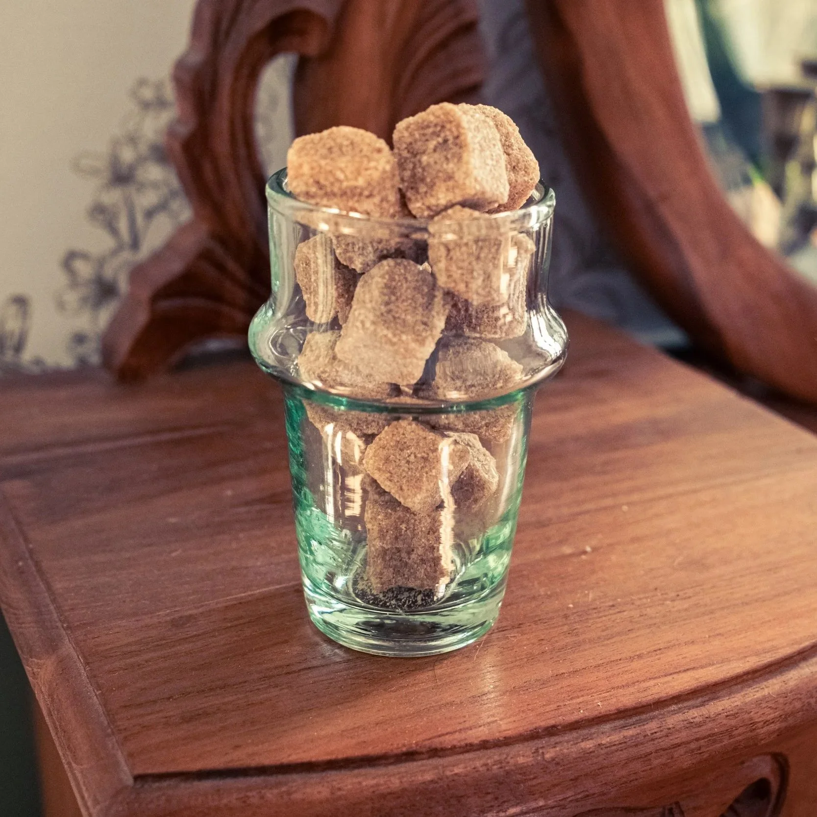 Verre transparent avec des cubes de sucre brun, placé sur une surface en bois. - Photographe packshot à La Réunion