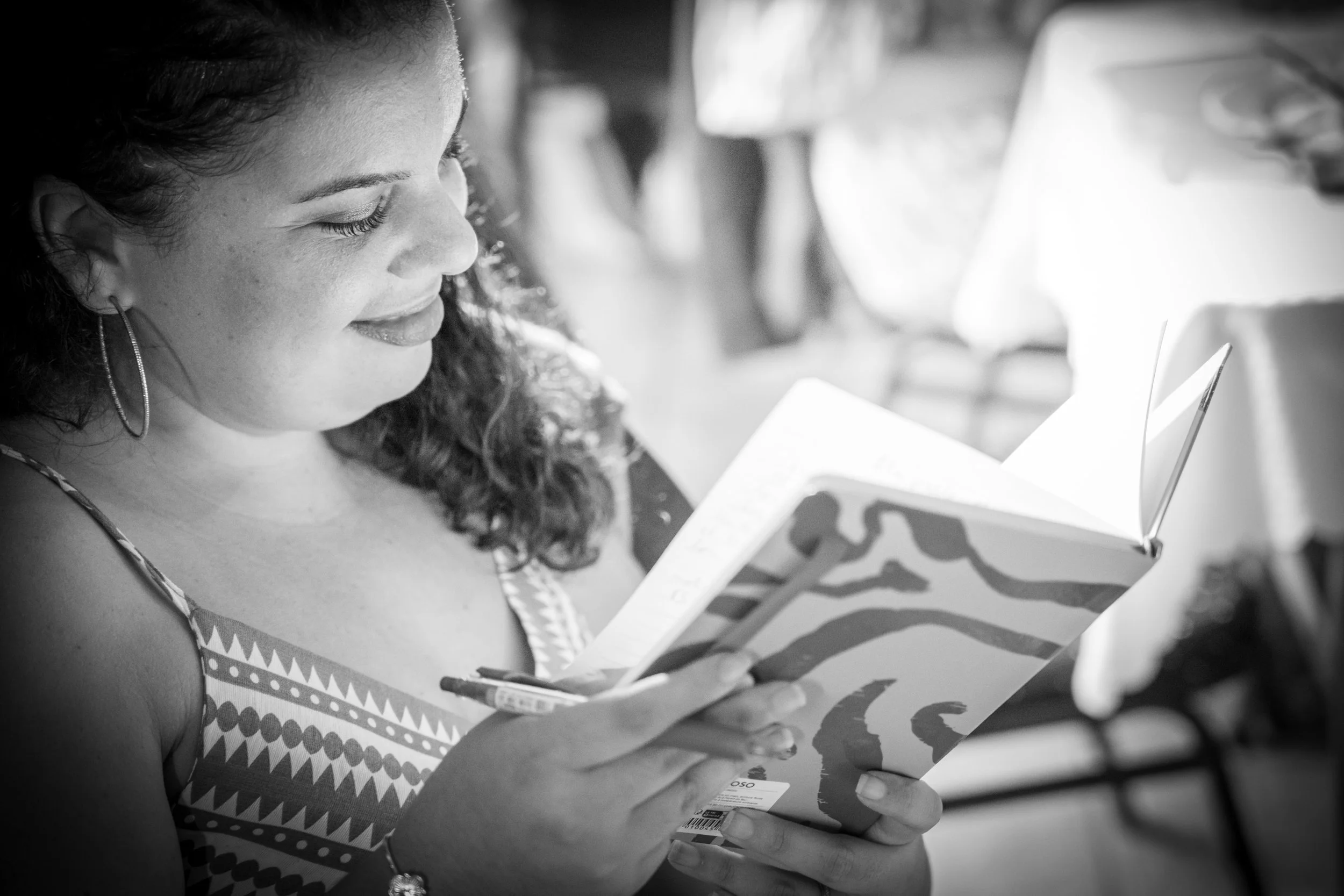 Portrait en noir et blanc d’une femme souriante écrivant dans un carnet — Photographe lifestyle à La Réunion