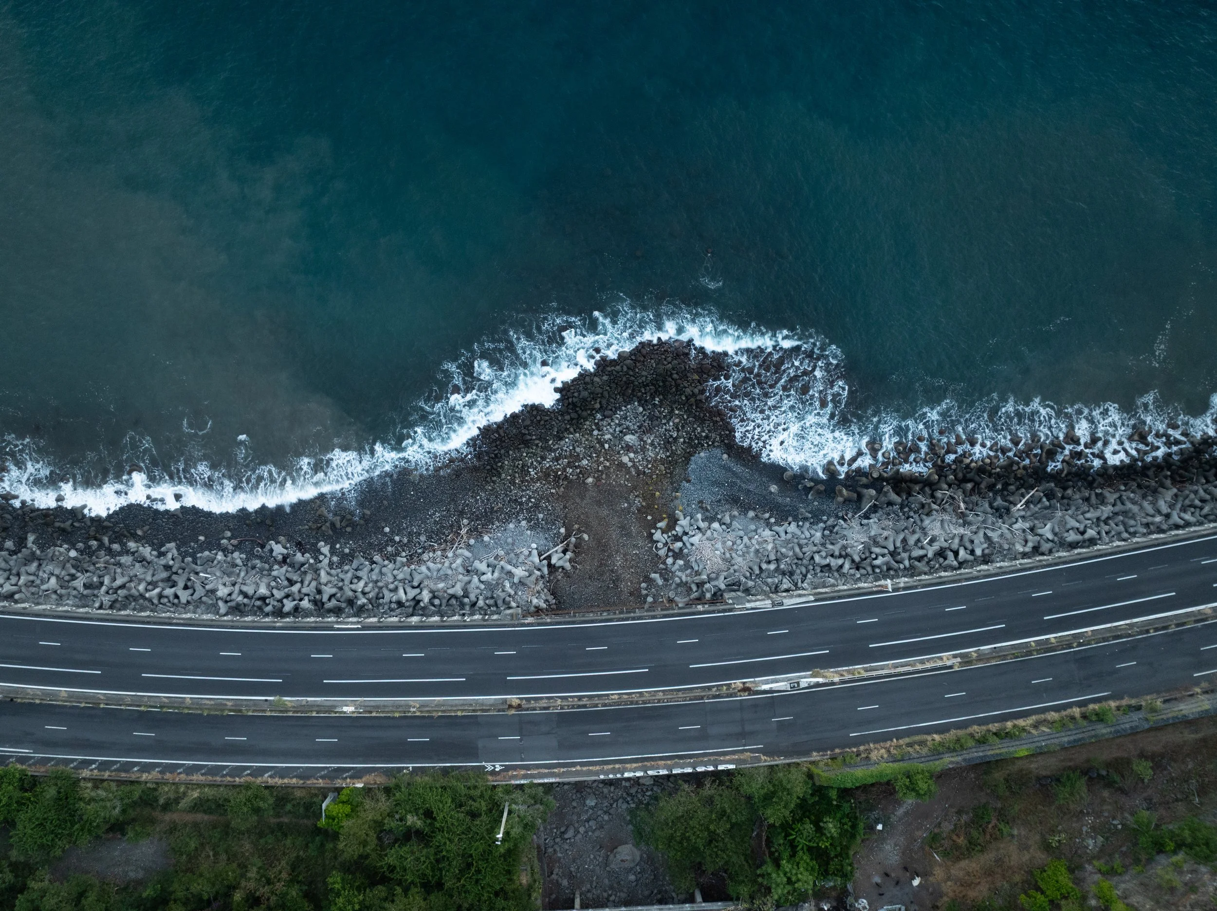 Nouvelle route du littoral, La Réunion. Vue aérienne d'une route côte à côte avec la mer, roche et végétation en dessous. - Photographe voyage à La Réunion