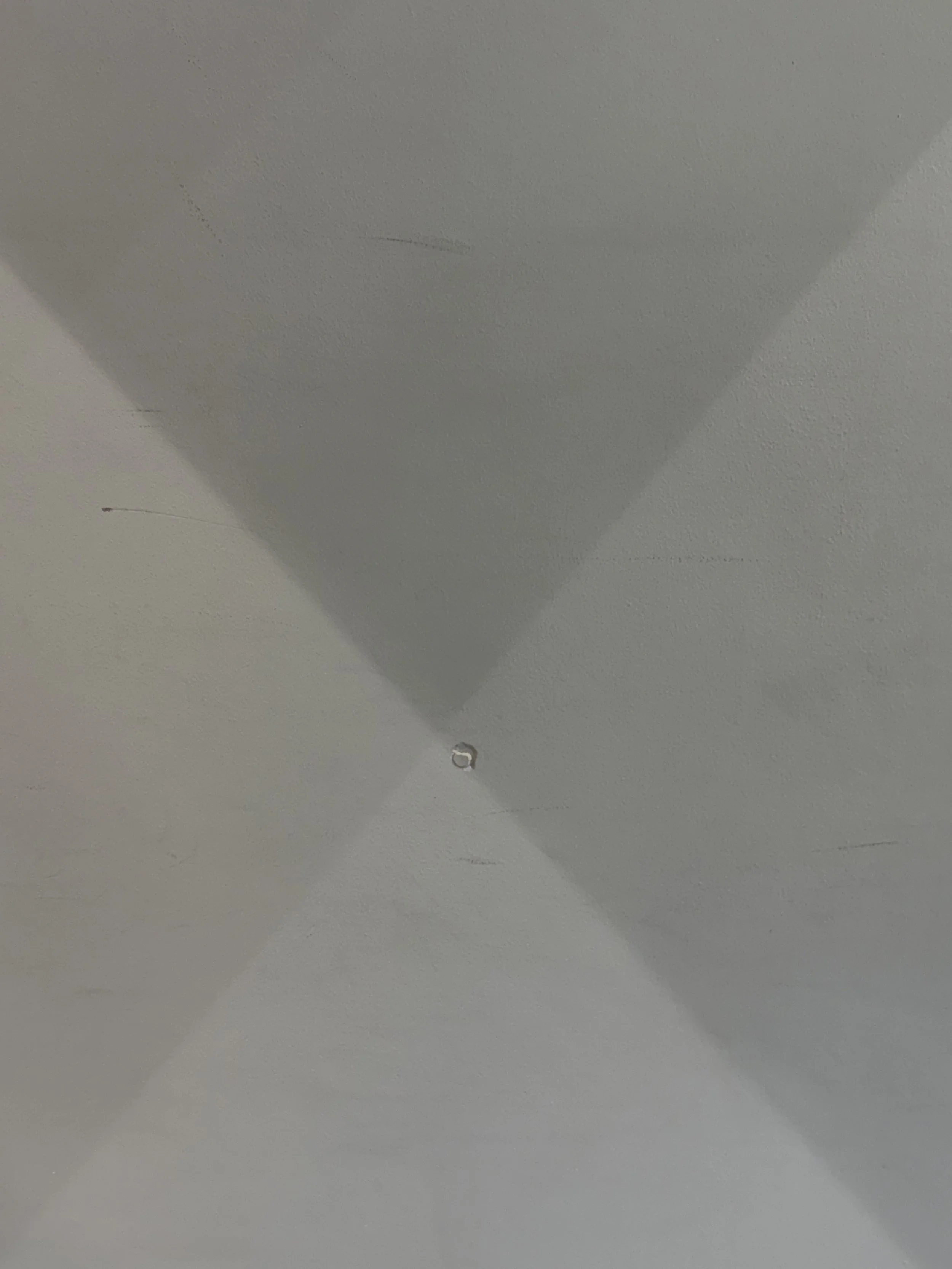 Ceiling with some minor damage and a small hole.