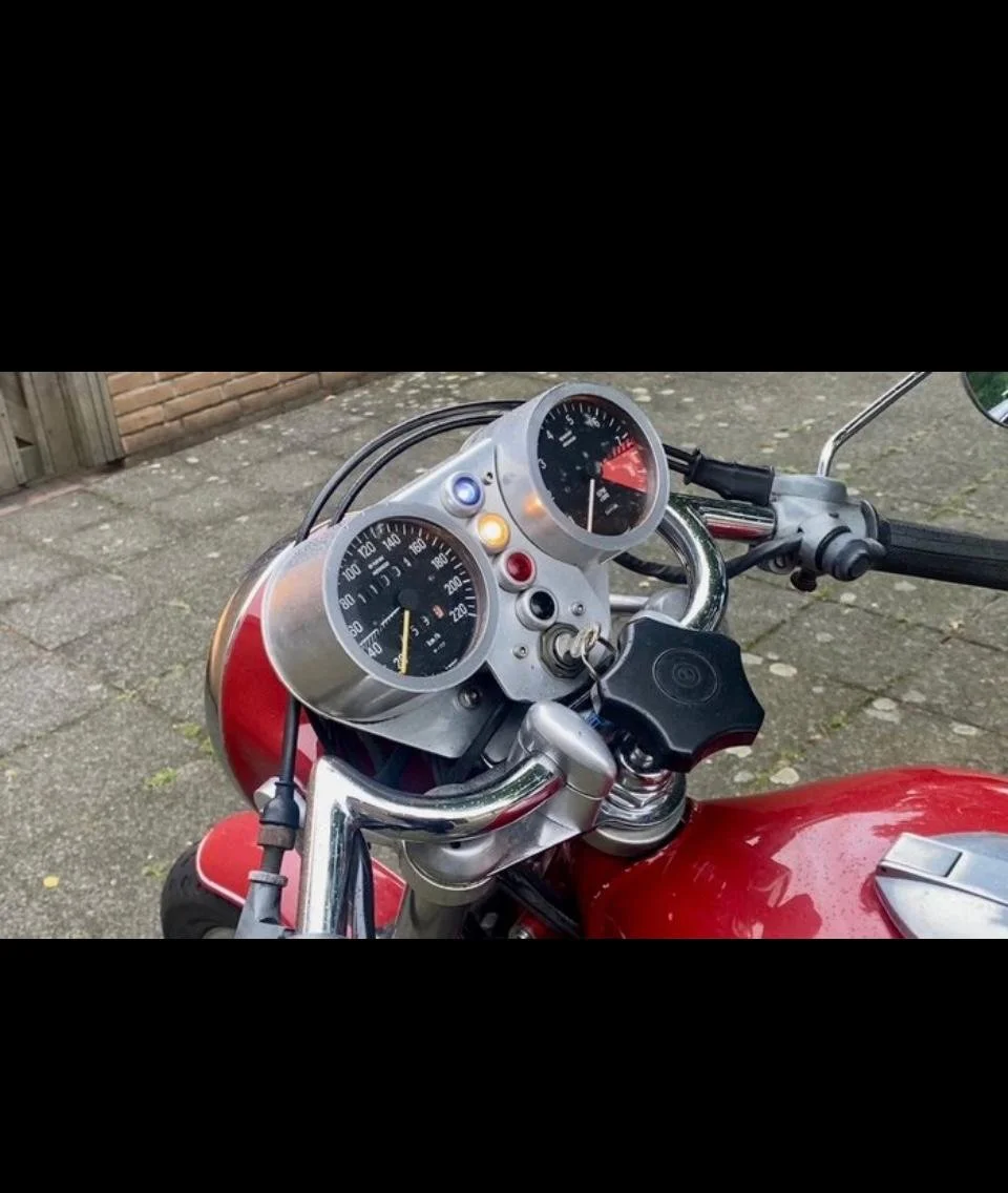 Tablero de una motocicleta con instrumentos y un teléfono móvil en un soporte