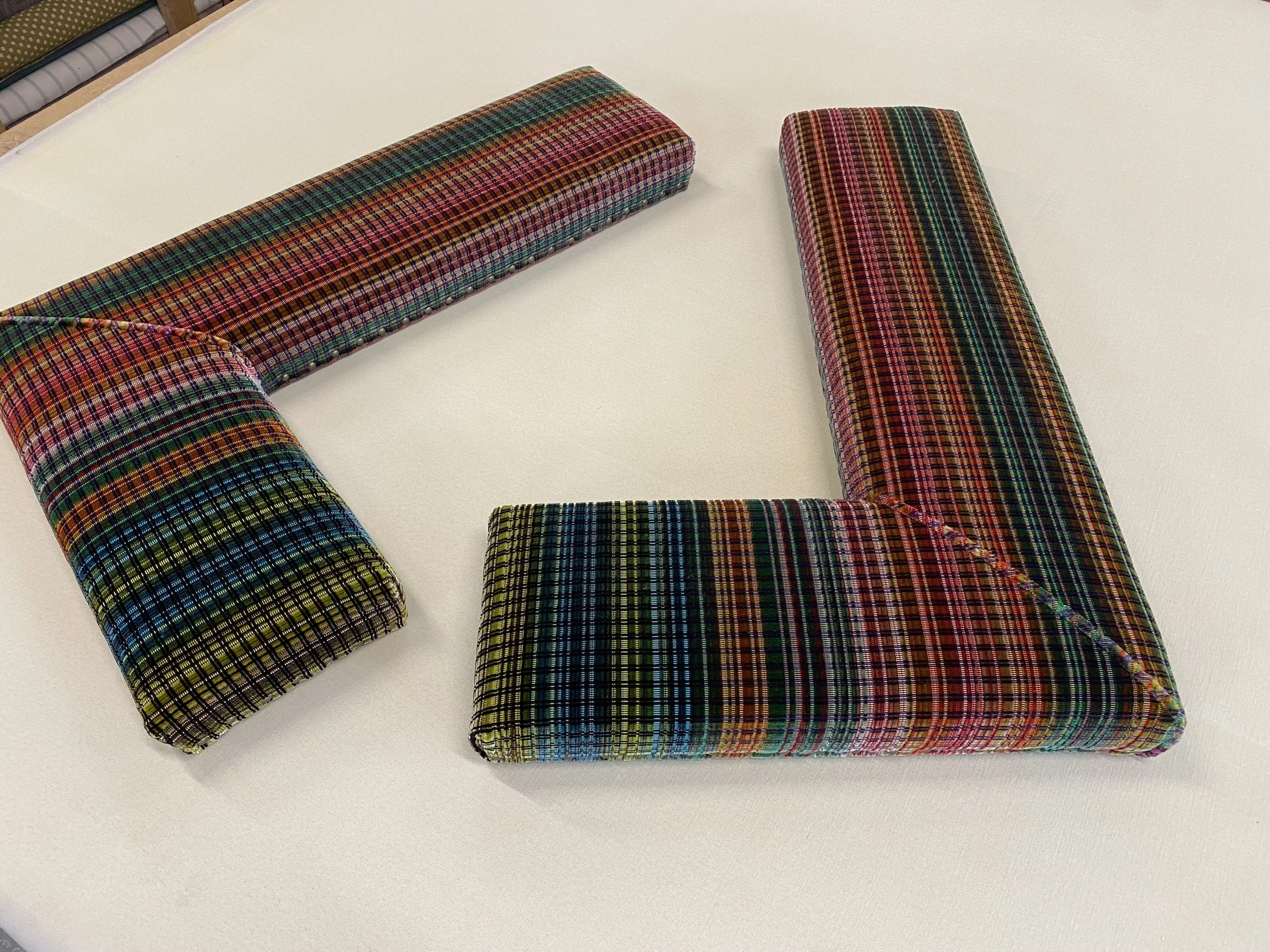 Colourful stripe design velvet fabric on a pair of fireplace fender seats.