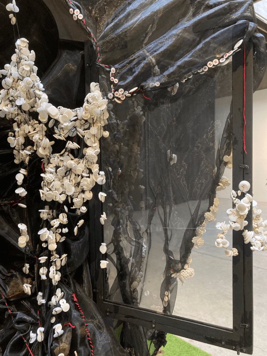   Yue Xiang    Witness,  2025  10’ x 16’ x 6’3  Broken china, Buttons, Chiffon,  Dried flowers, Embroidery thread,  hand labor, Palestine vs Hong Kong 2023 Asia Cup Group C game comments, Radio speaker,  Refurbished cabinet, Recorded artist breathing