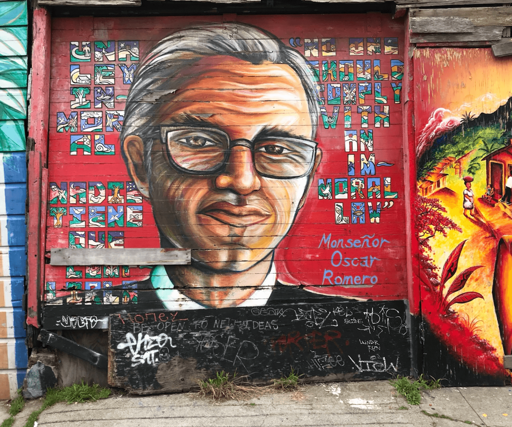 Battered mural in 2026, NO ONE SHOULD OBEY AN IMMORAL LAW, Homage to Monsignor Oscar Romero, 10’ x 12’, Acrylic mural on wooden garage door, Balmy Alley. Juana Alicia ©1996