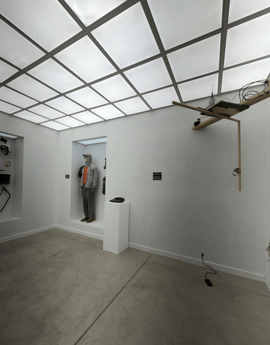 Interior of the constructed gallery, showing the mannequin, pedestal with telephone, and “The Rotational Scan” apparatus at right with foot pedal on the floor.