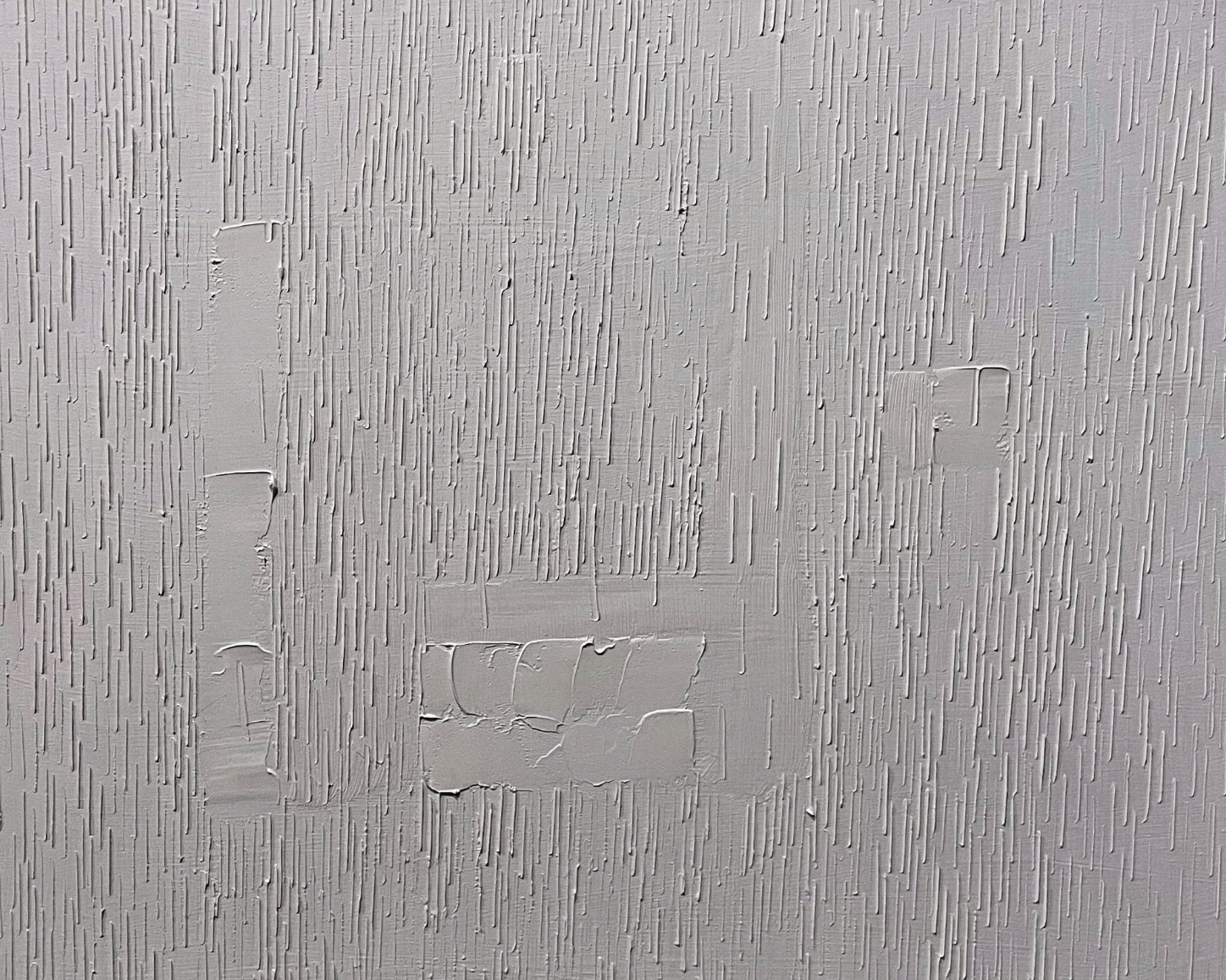 a gray abstract artwork that looks like a textured wall