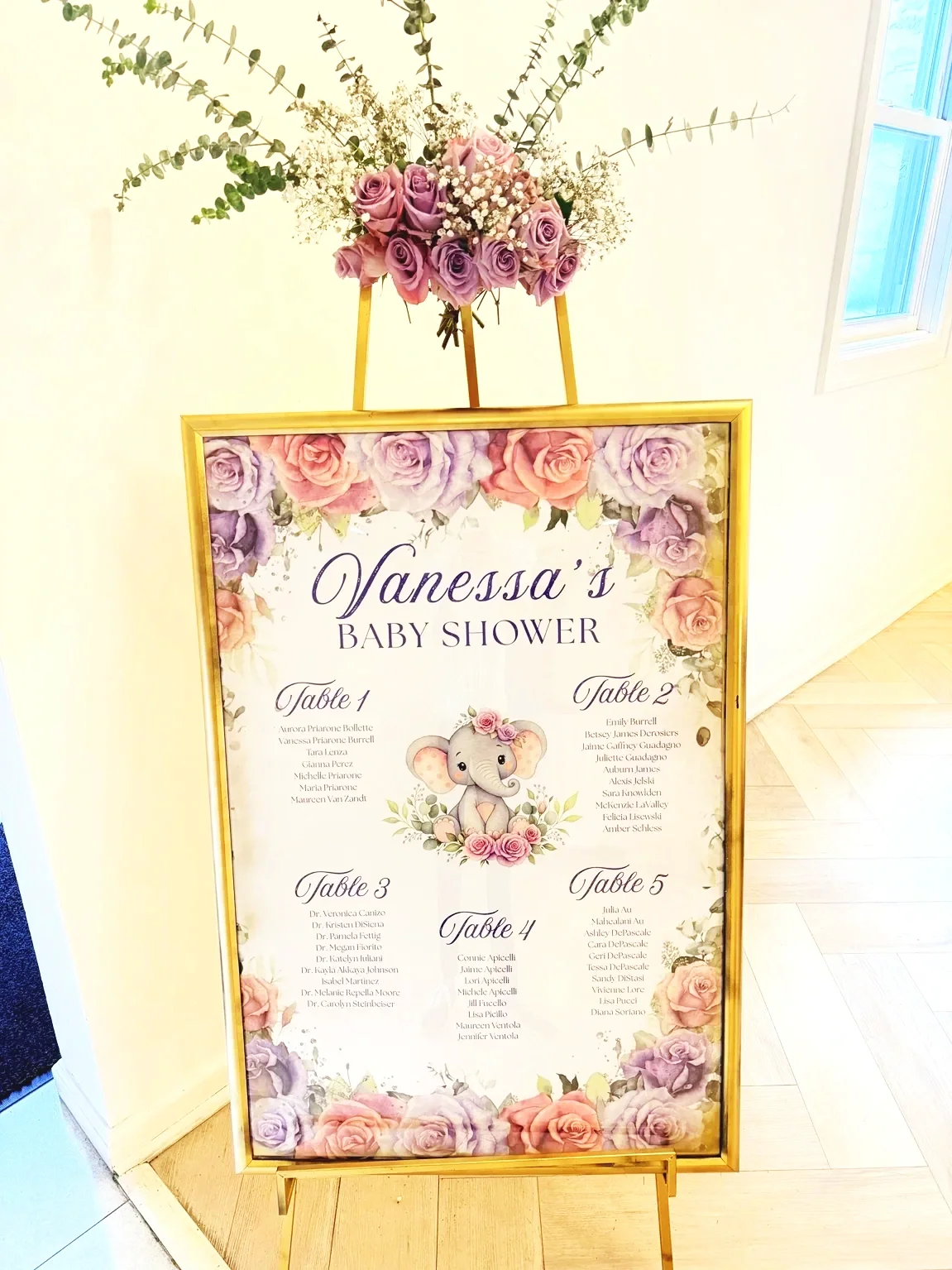 Baby Shower Seating Chart sign on an easel with flowers
