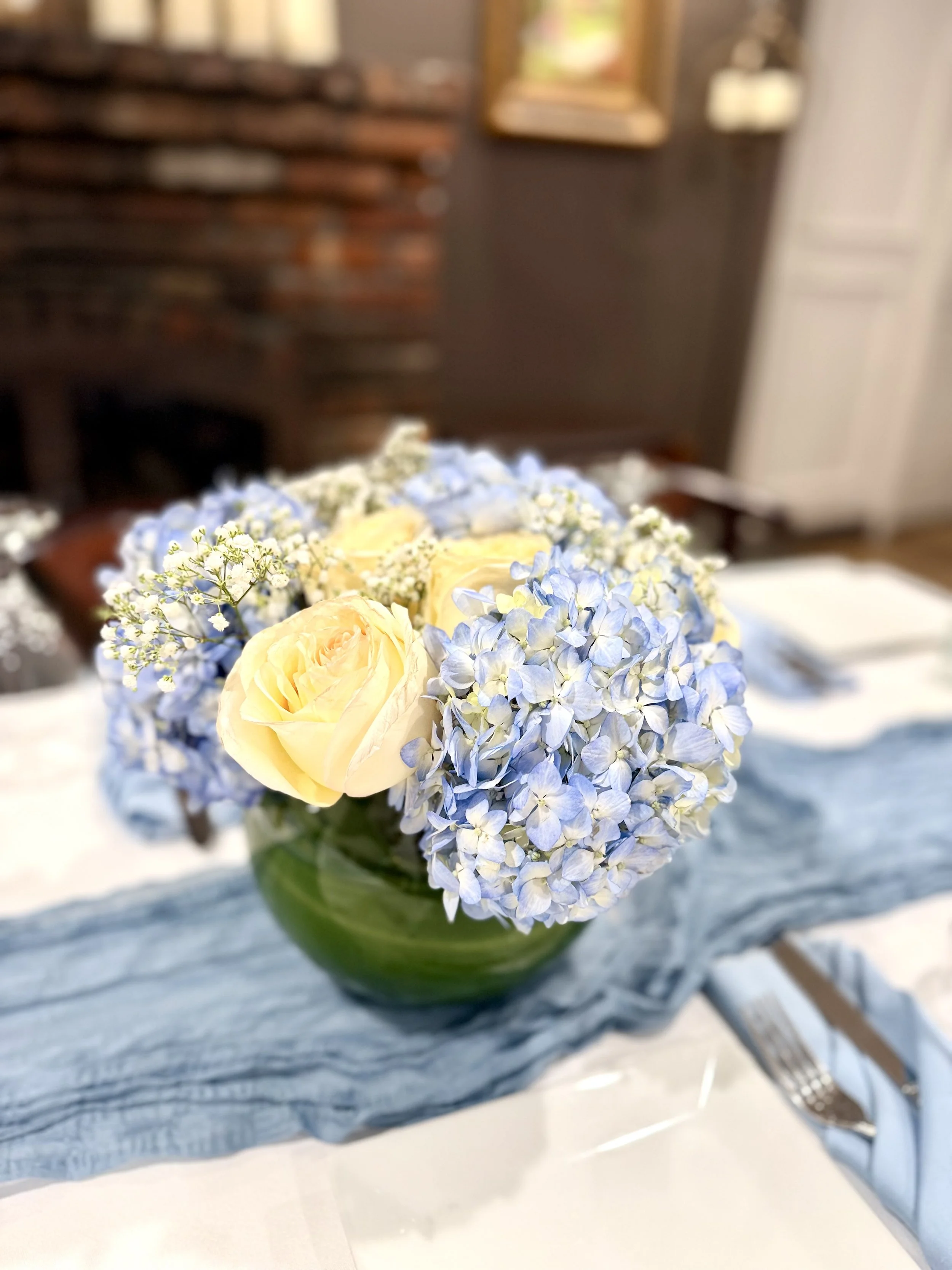 First communion flower centerpiece in NJ featuring blue hydrangeas and white roses