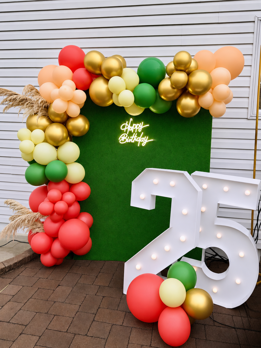 Luxury 25th birthday balloon backdrop with custom marquee numbers, green hedge wall, neon happy birthday sign, and organic balloon garland by North Jersey event decorator Stellar View Events