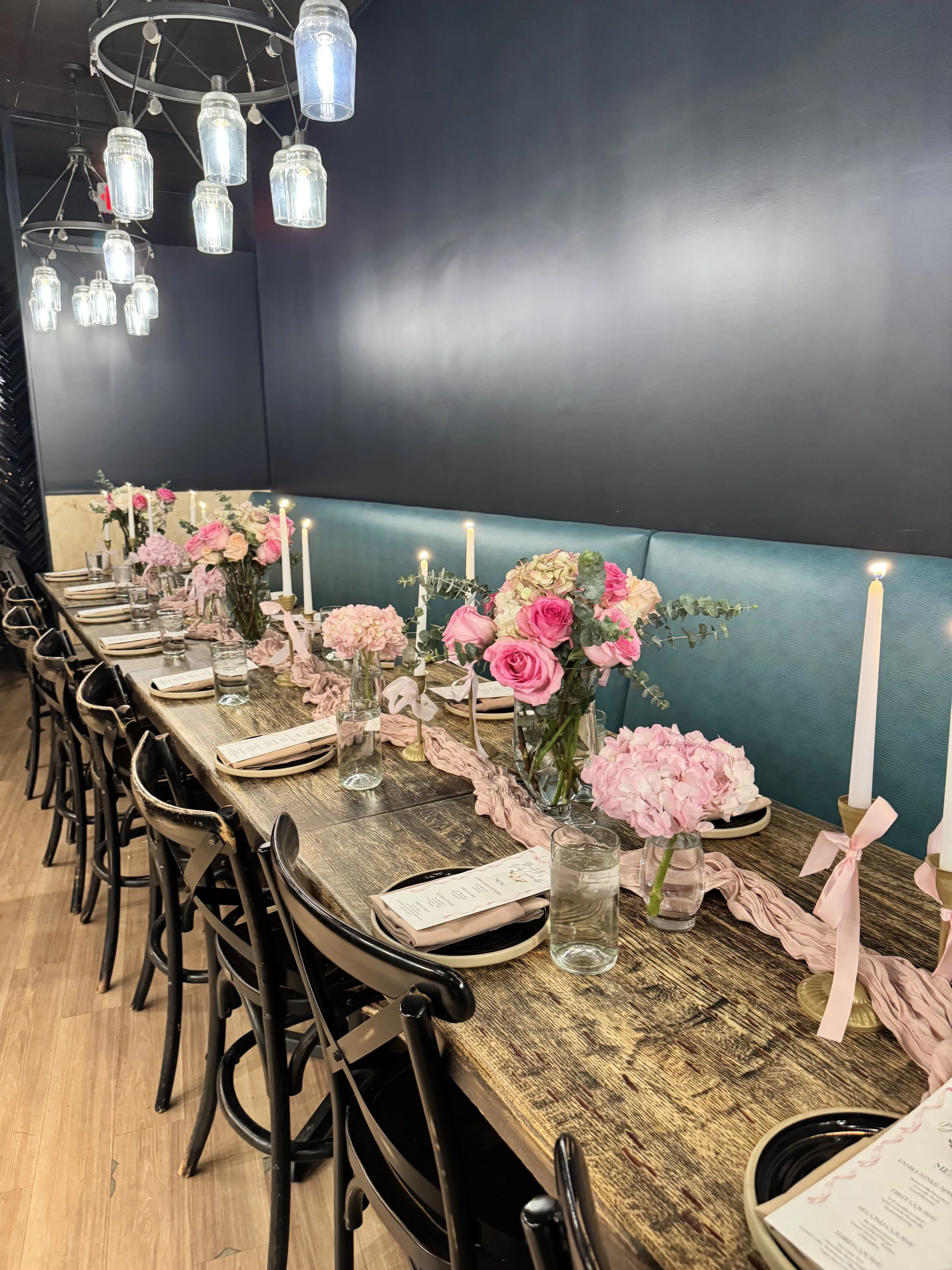 Roses and candle centerpieces with pink bows for baby shower