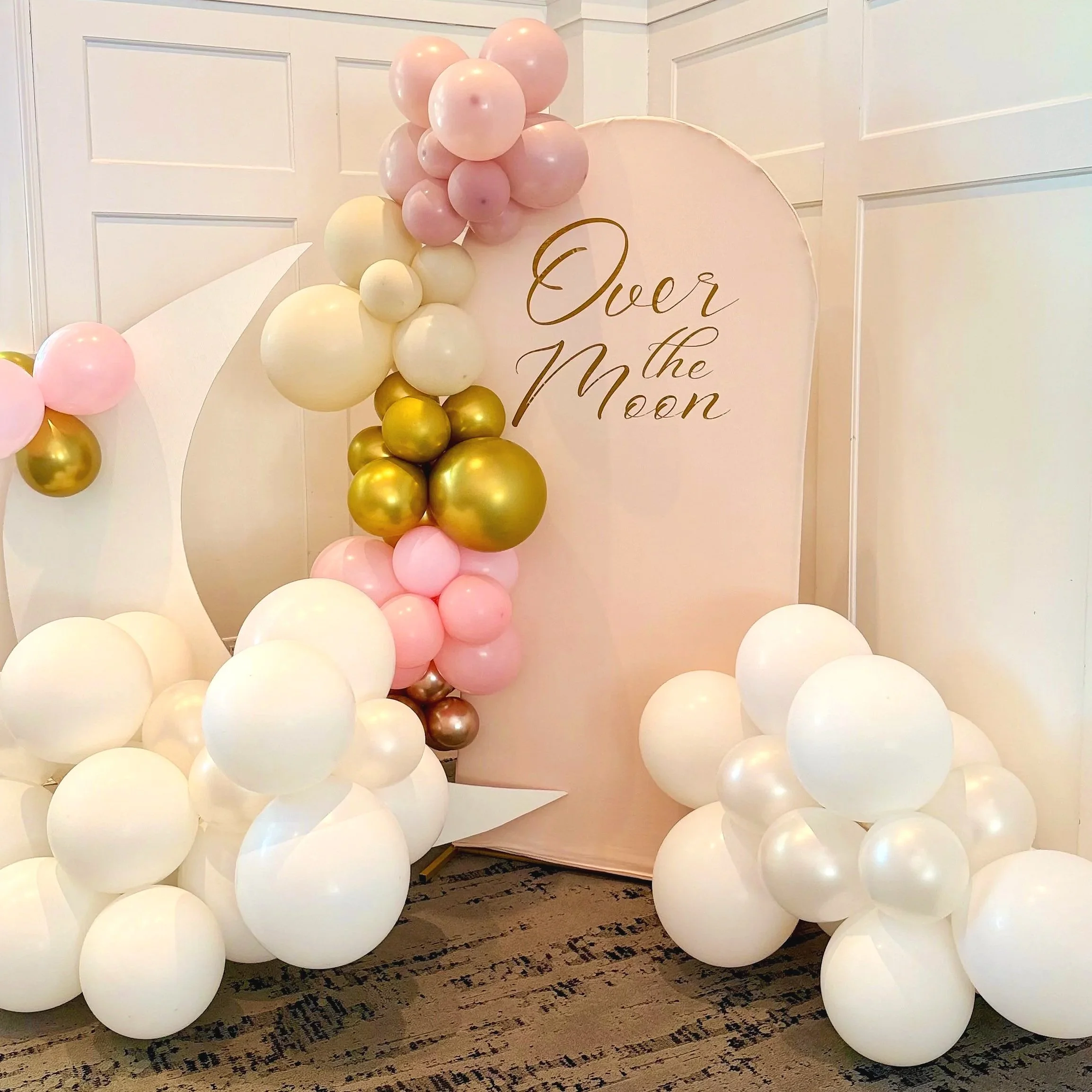 Over the Moon baby shower balloon display in New Jersey featuring soft blue, white, and gold balloons with cloud details, crescent moon décor, and elegant event styling for a dreamy celestial-themed celebration
